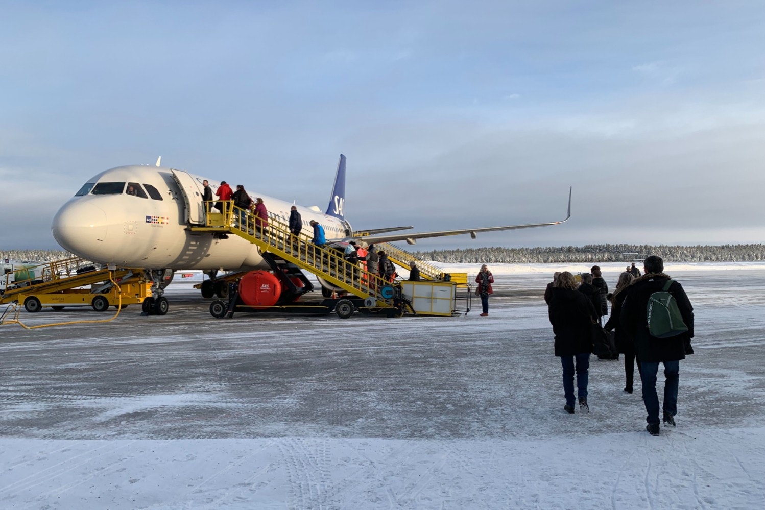 People boarding a plane in the snow