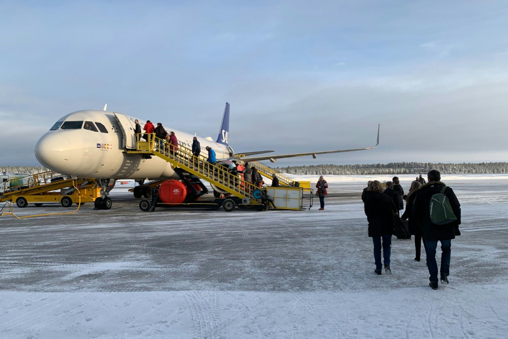 People boarding a plane in the snow