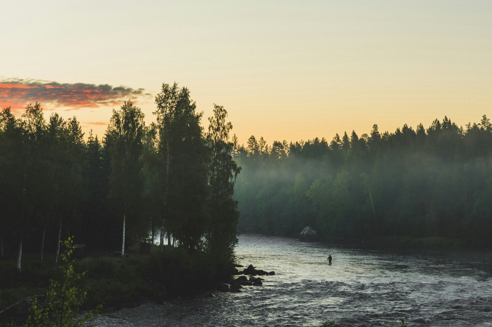 A solitary man fishes with a fly rod in a river in Sweden; World's best rivers for fly fishing