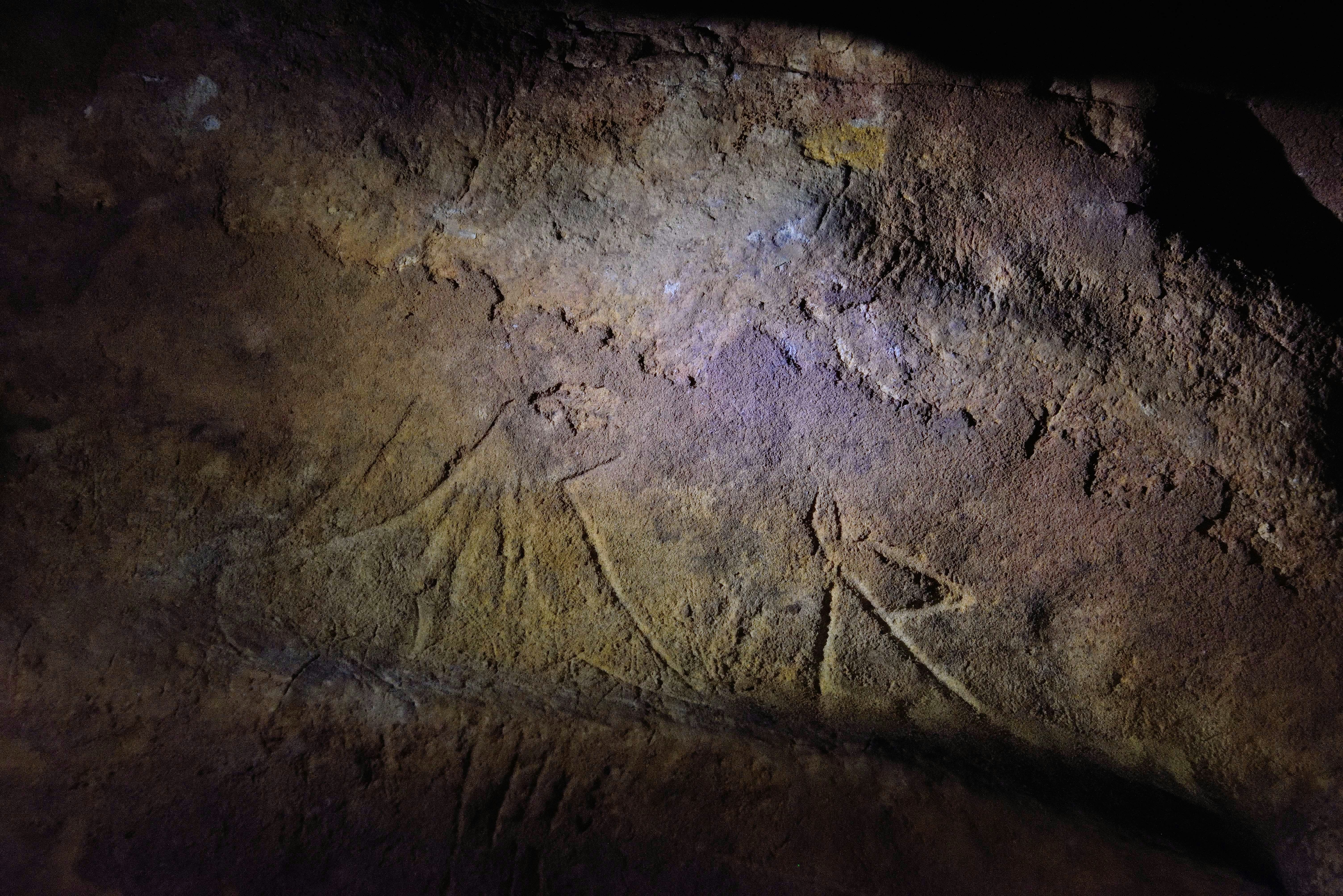 Geometric abstract art engravings on the wall of a cave