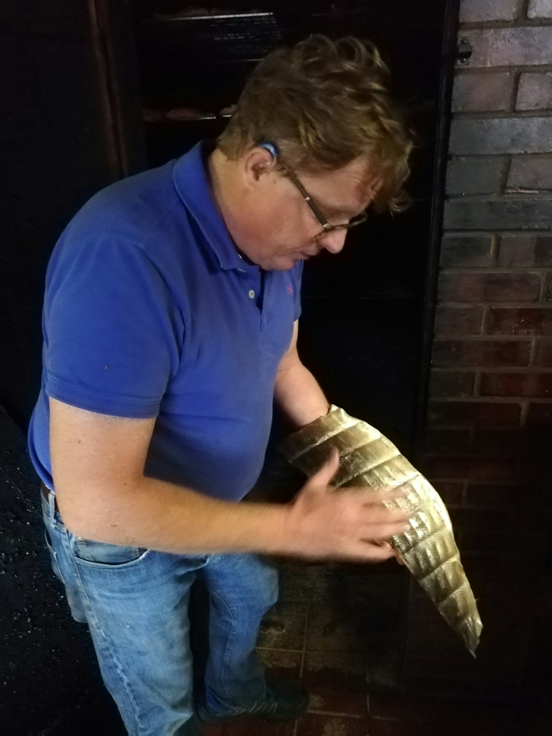 A man holding a huge side of smoked salmon in one hand and gesturing with the other on a tour of Brown and Forrest Smokery, Somerset