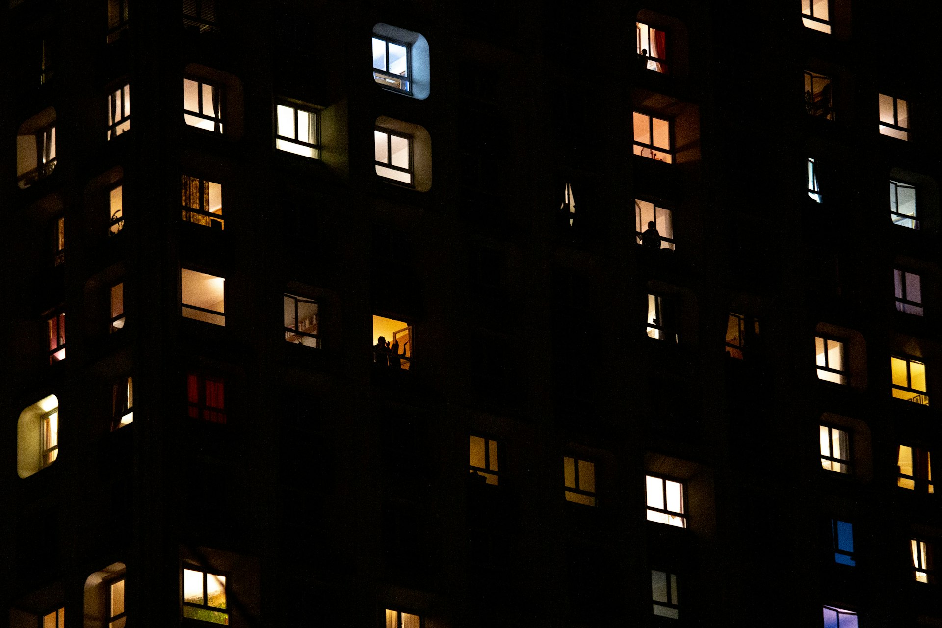 People look out from their window as people clap in support of medical staff in France on 17 March in Paris