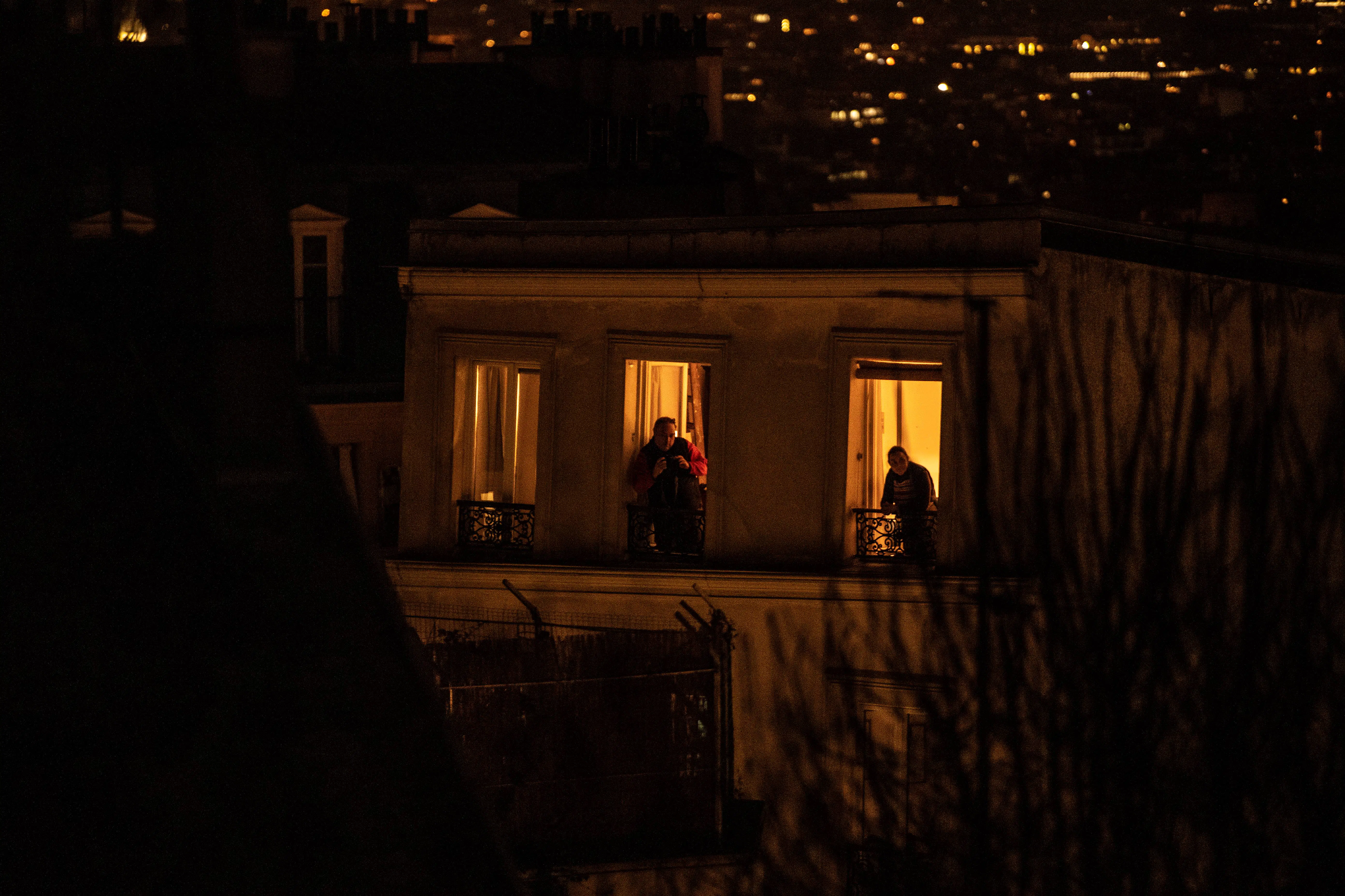 France COVID-19 Tribute.jpg Two men look from their balconies in Paris, on March 17, 2020, as a strict lockdown comes into in effec