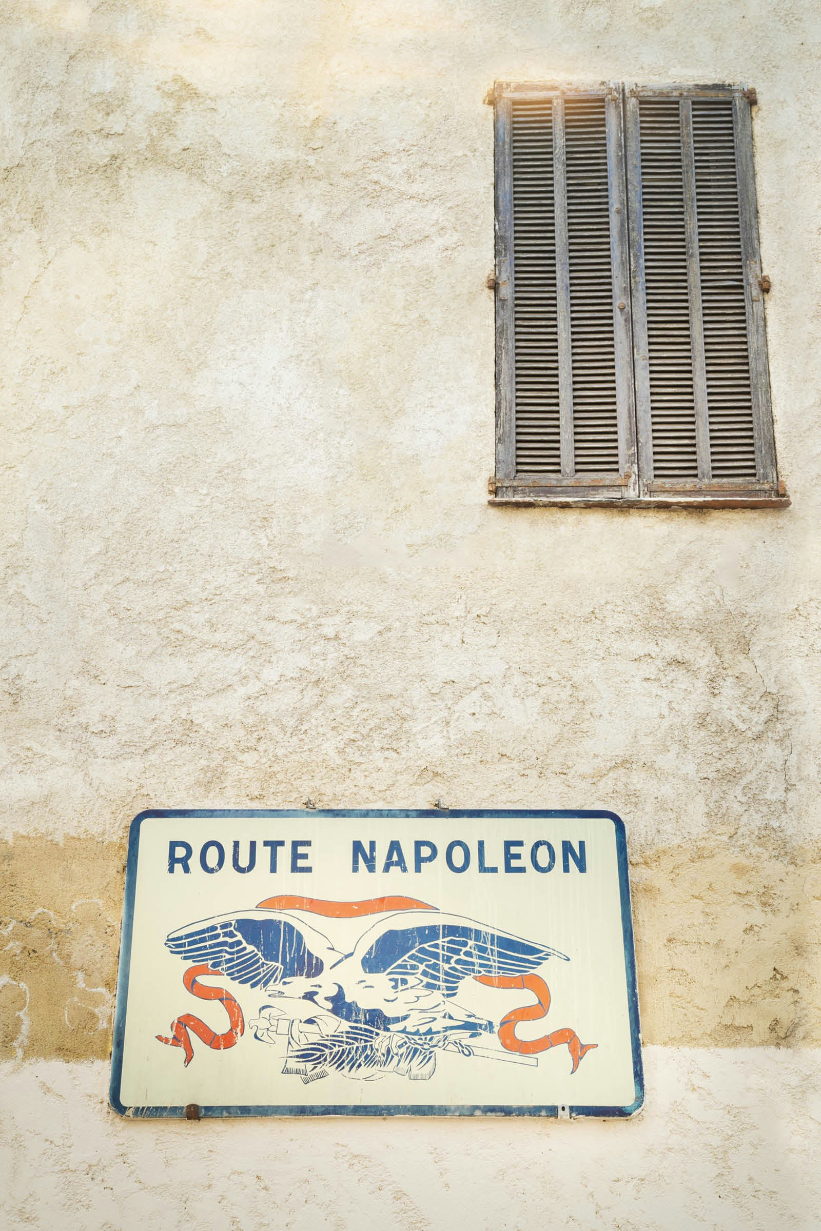 An eagle marks a road sign at the start of the Route Napoléon
