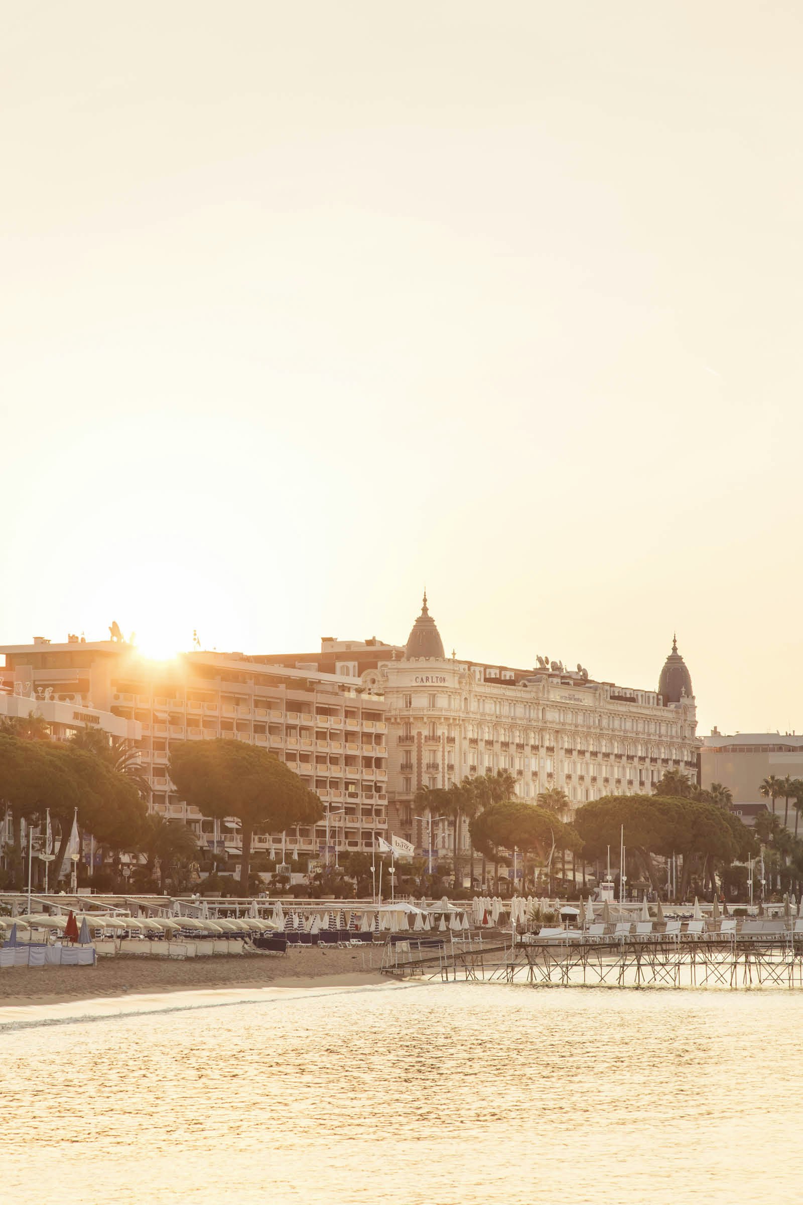 The sun breaks over the roof of the InterContinental Carlton in Cannes