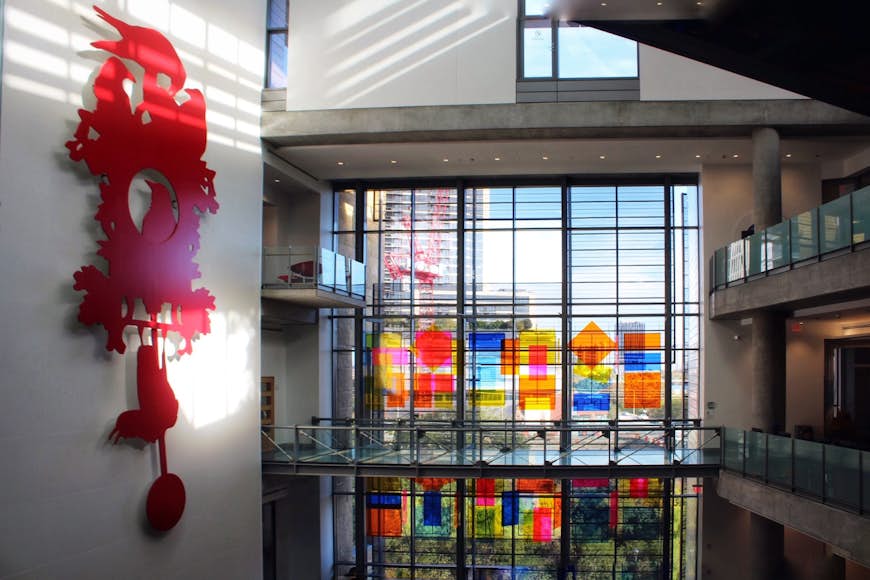 A large red clock and colorful blocks on a window are some of the brilliant design elements in the Central Library, in Austin Texas