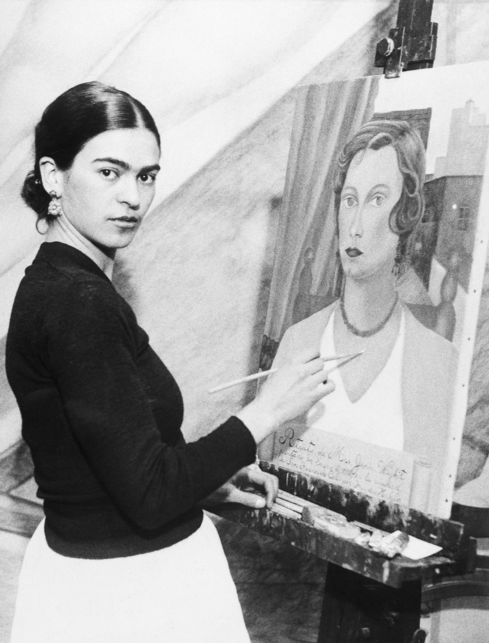 Photo shows Frida Kahlo painting a mural