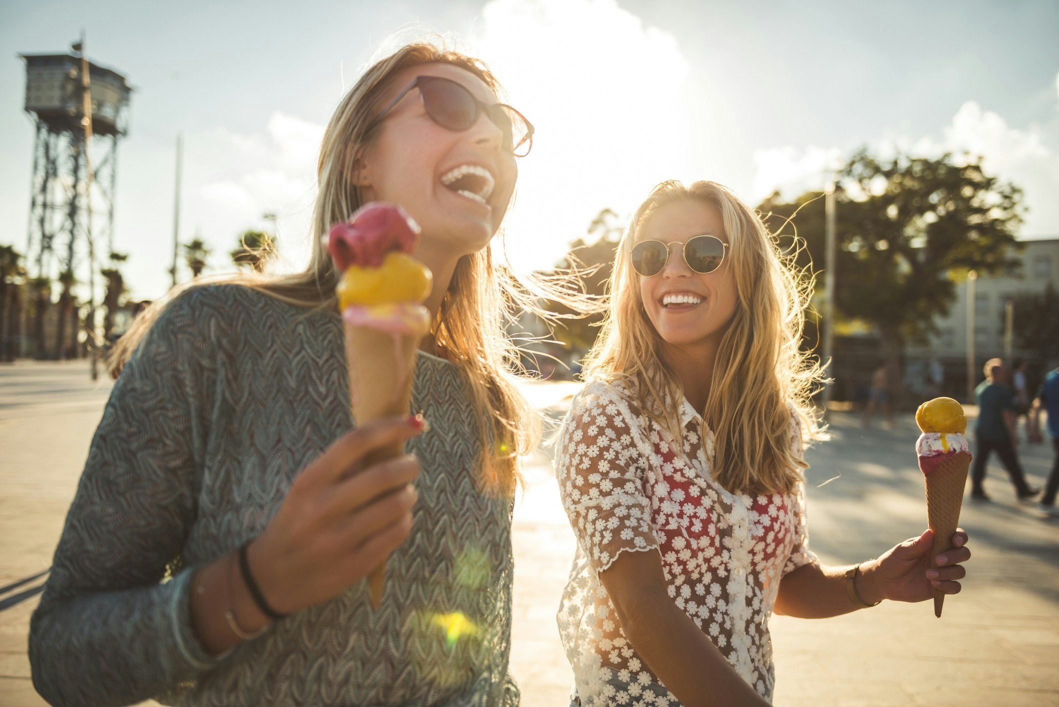 Two female friends laughing and eating ice cream