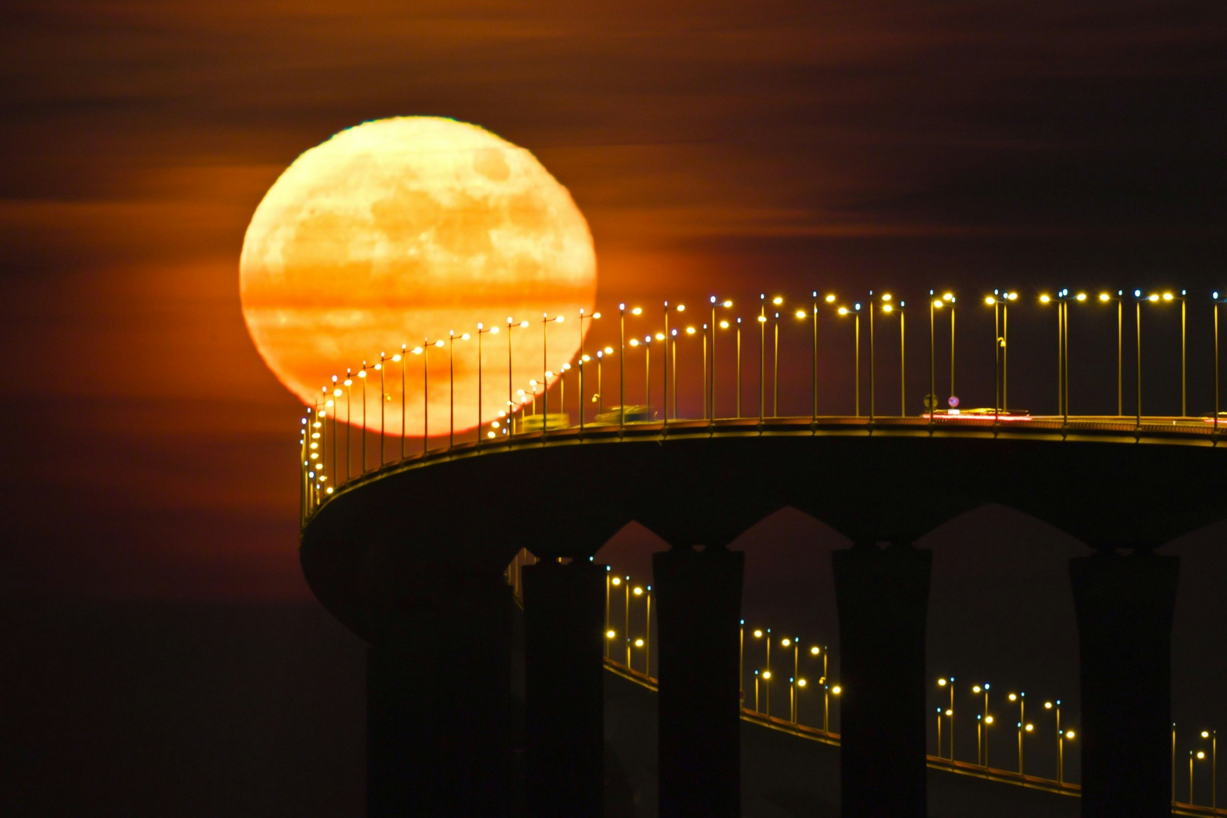 A full moon rising over the Re Island Bridge in Rivedoux