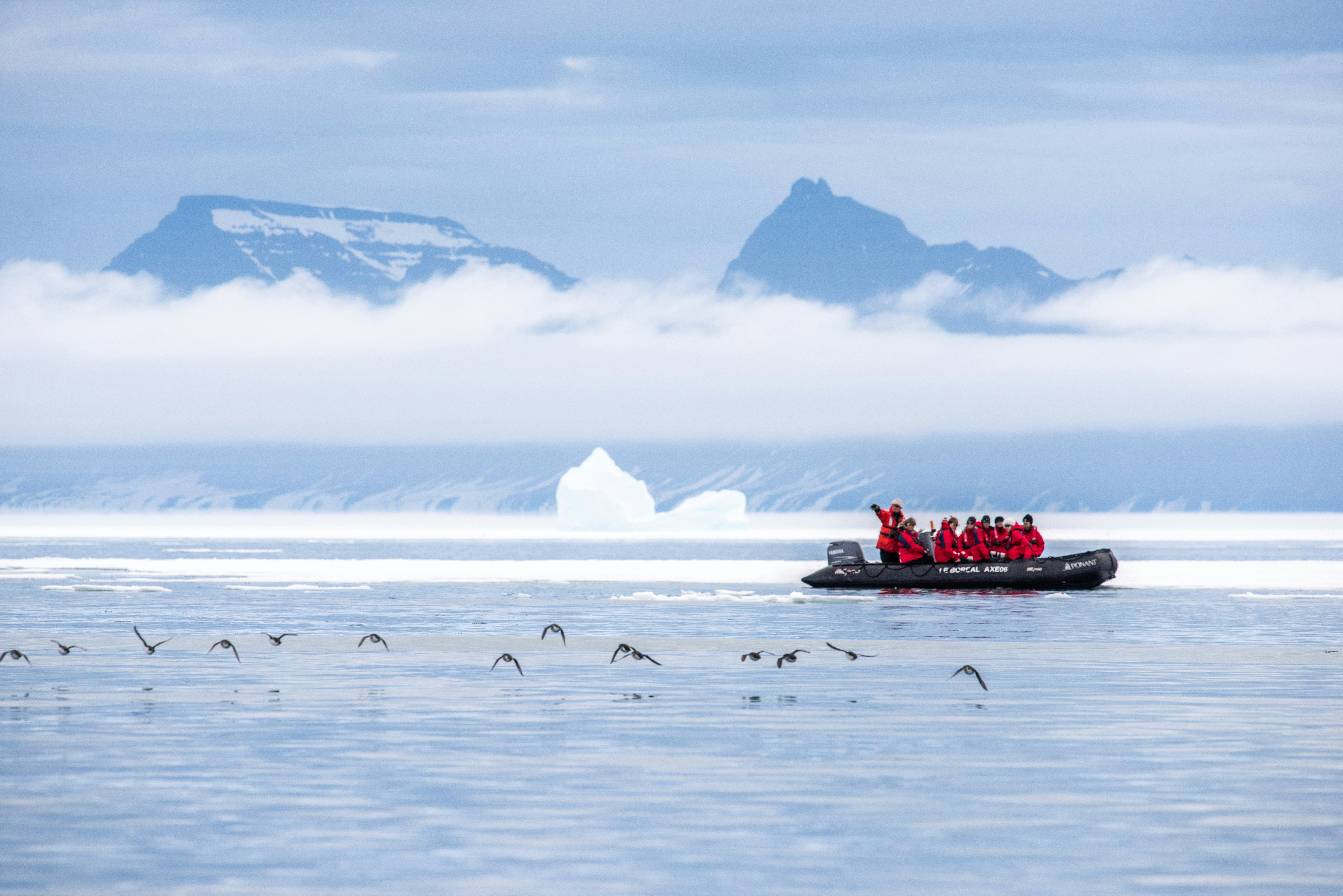 A dingy with passengers in red jackets.jpg