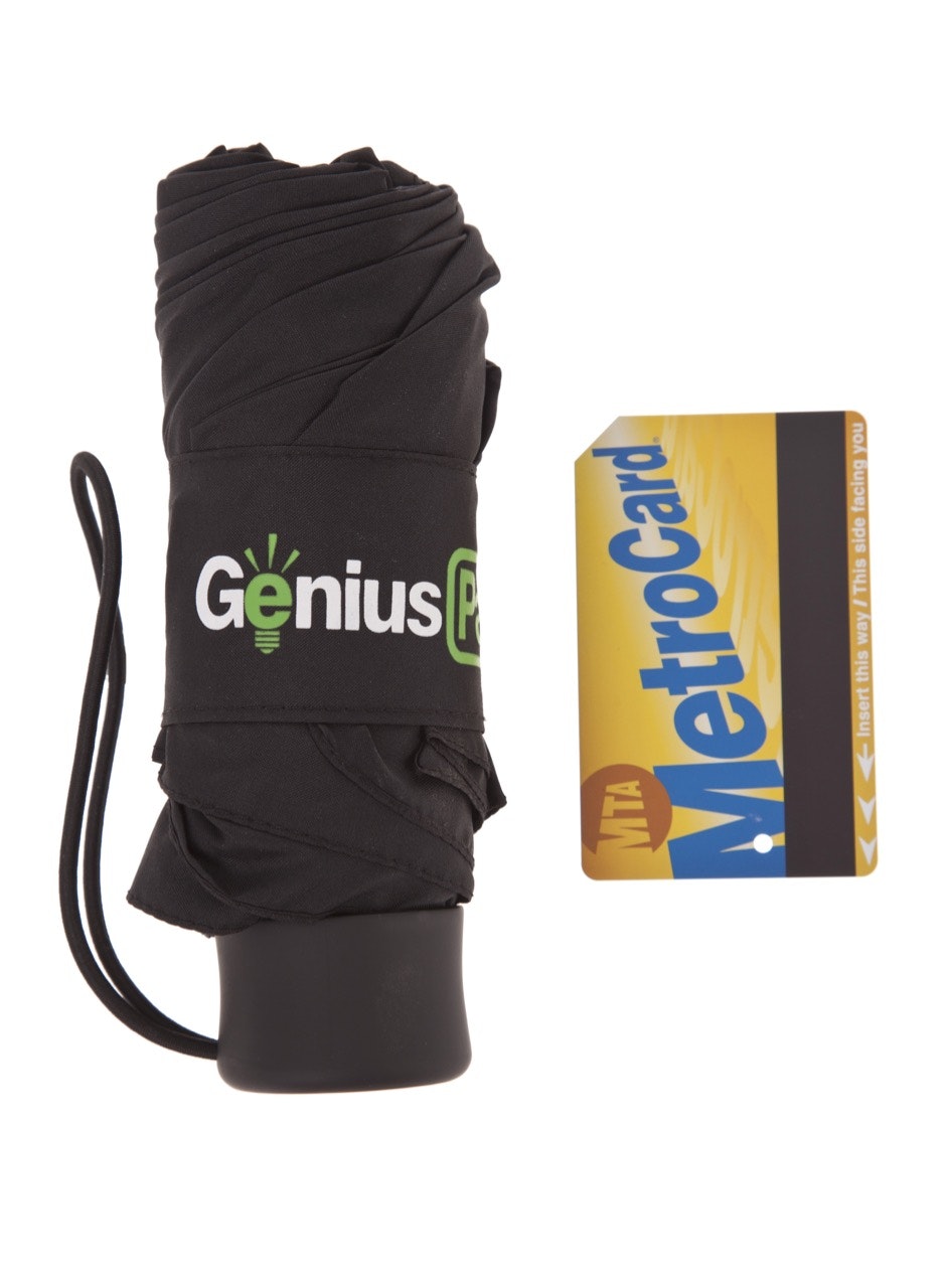 Genius Pack's micro travel umbrella next to a New York metrocard for scale