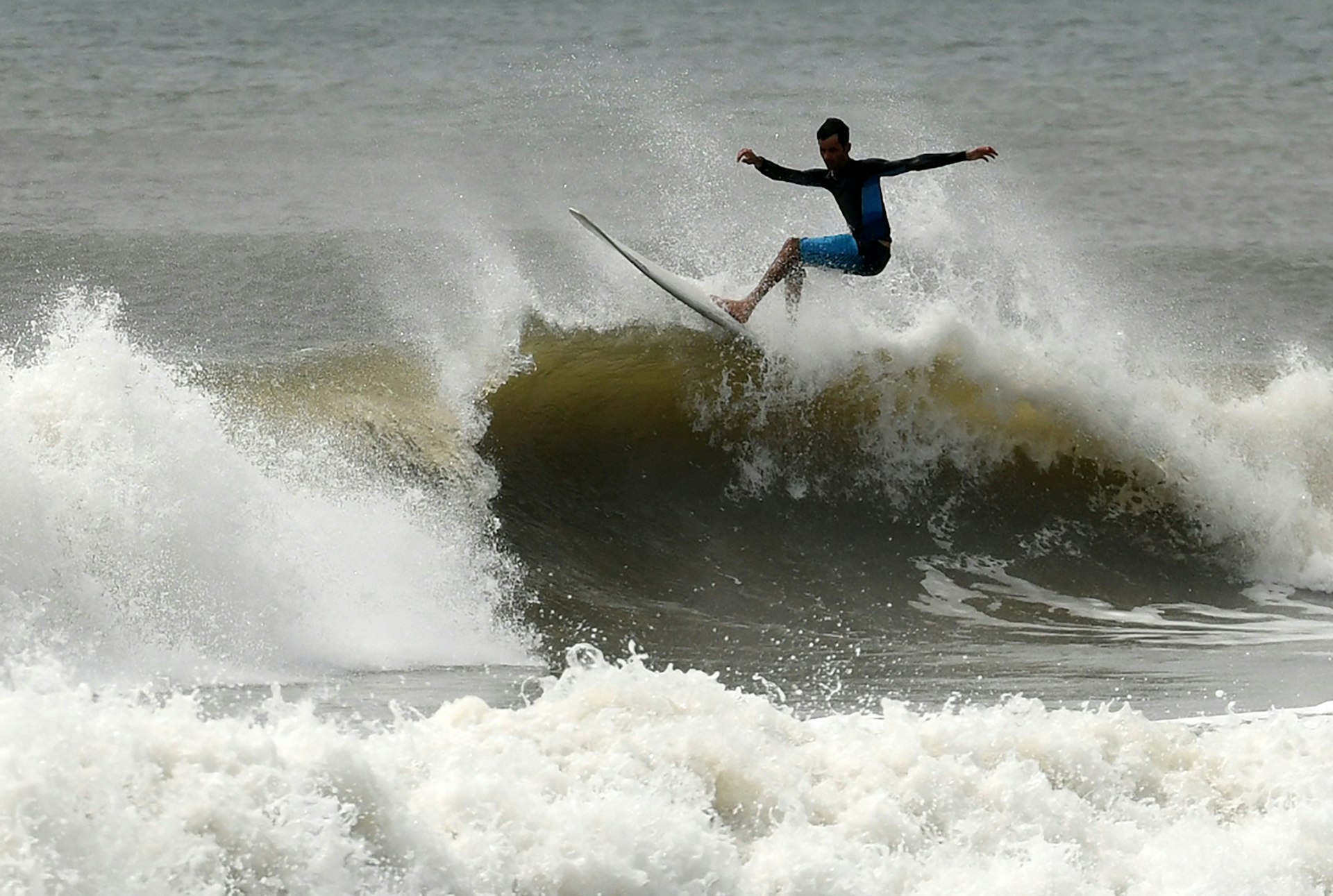 An Indian surfer rides a wave off the coast of Kovalam.