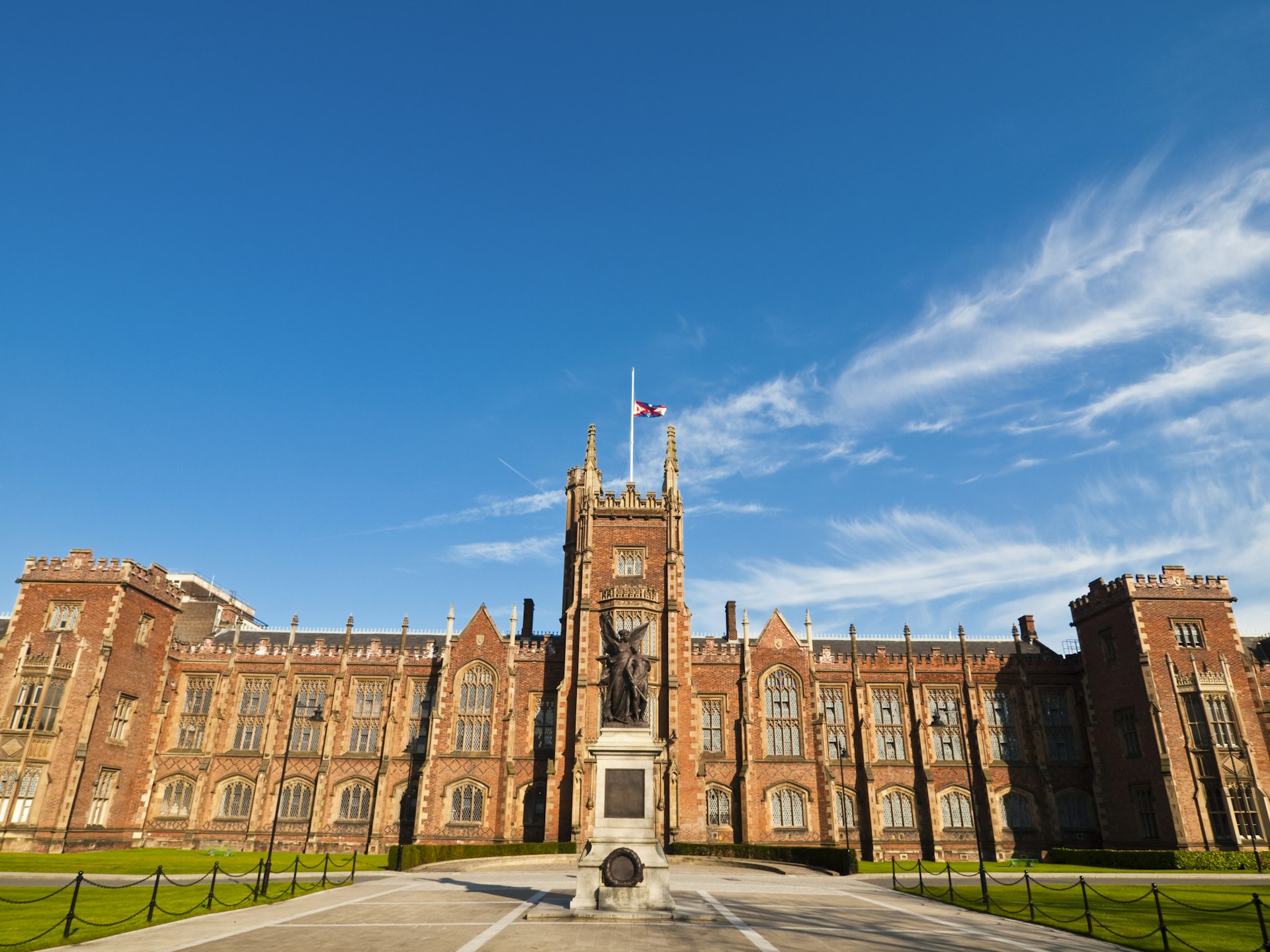 A view of the Gothic frontage of the main building at Queen's University, Belfast, with blue skies above.