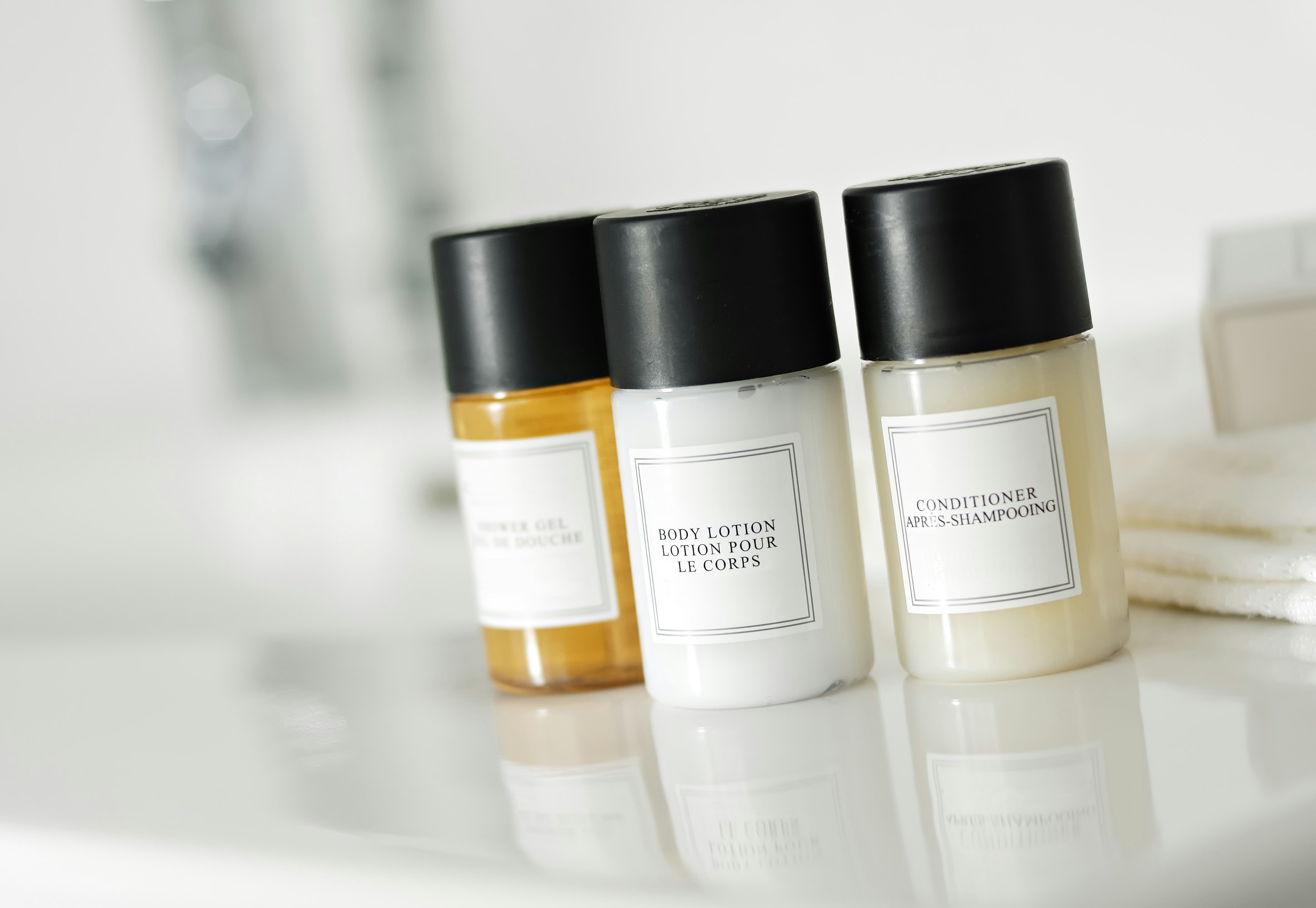 Mini shampoo, conditioner and soap bottles in minimalist packaging