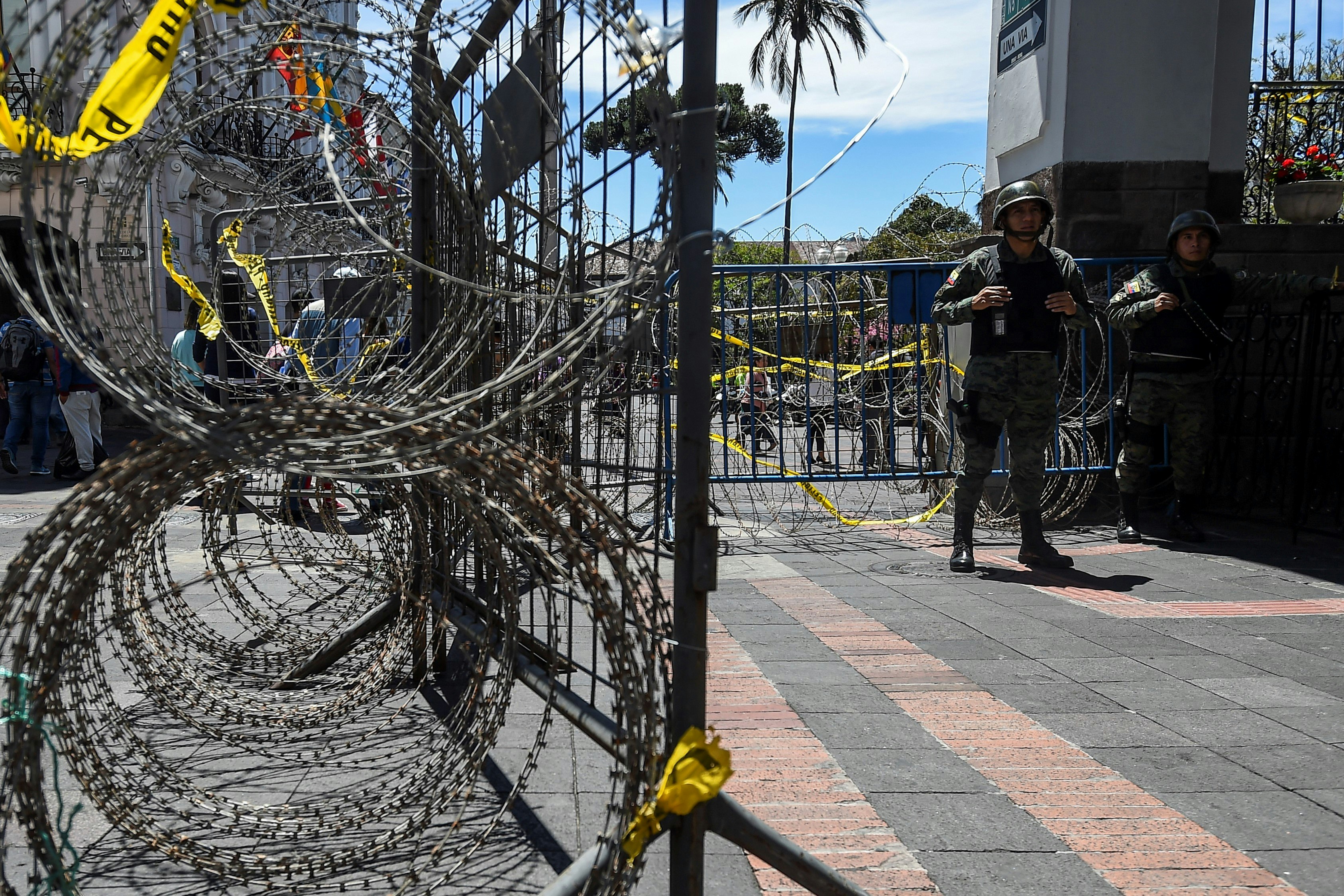 Rings of barbed wire next to men in military fatigues