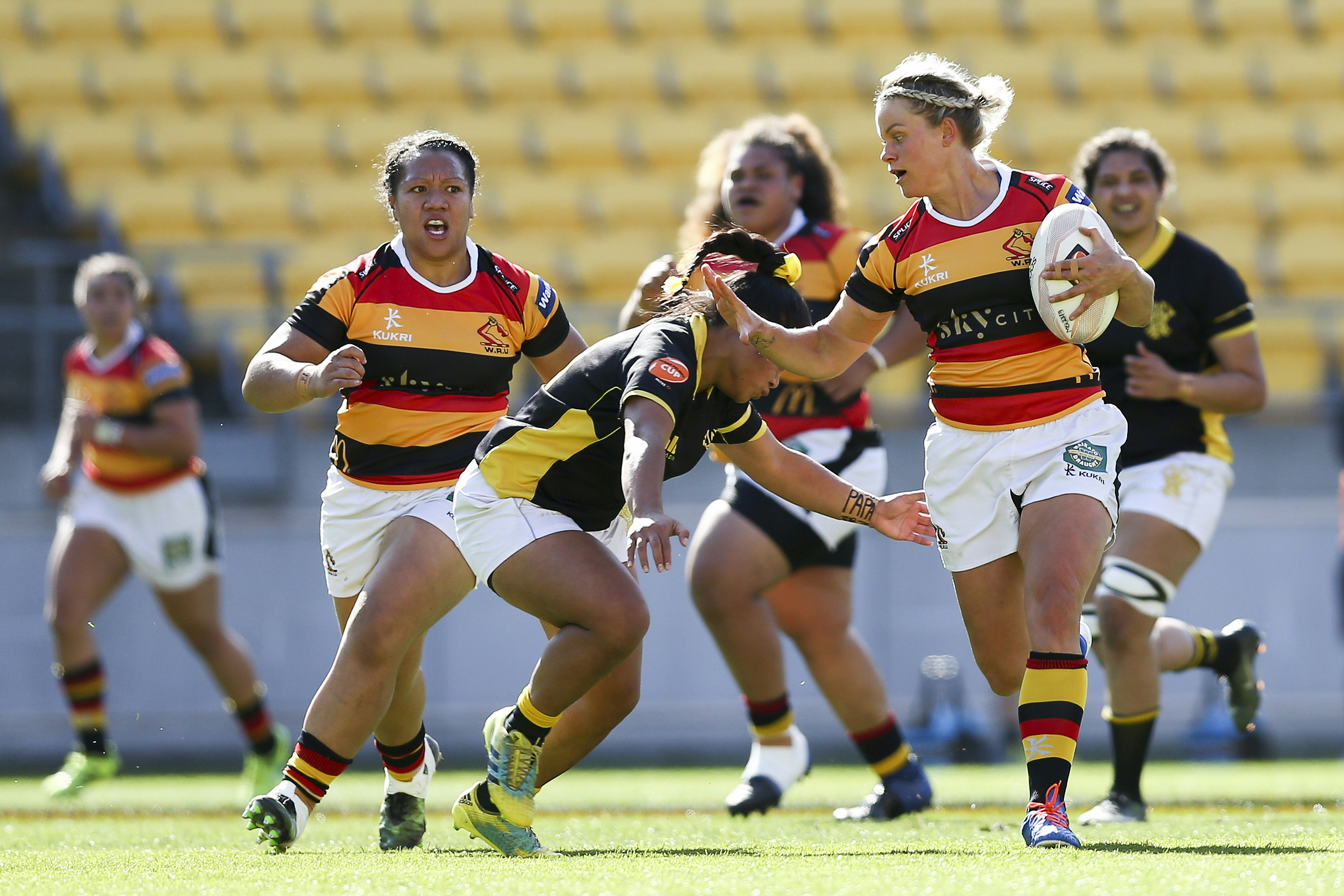 Chelsea Alley of Waikato, who is running towards the camera with ball in hand, is tackled during a match between Wellington and Waikato at Westpac Stadium.