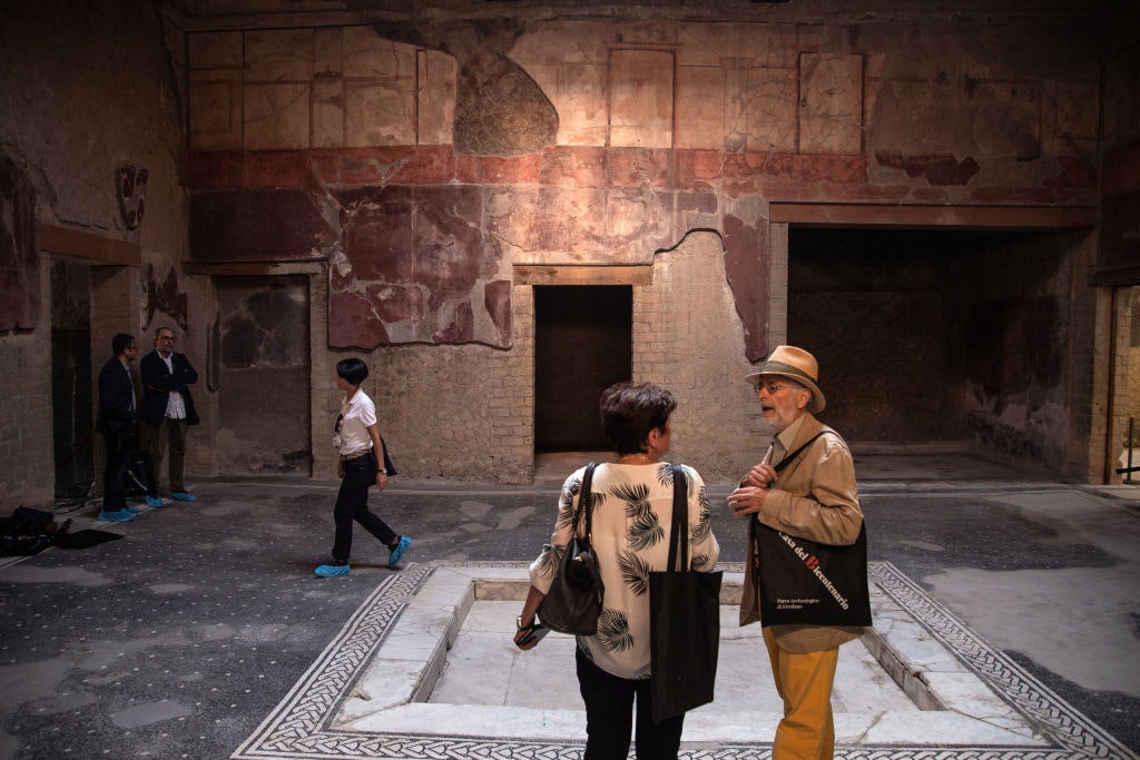 Tourists in a mosaic-tiled room of the House of the Bicentenary