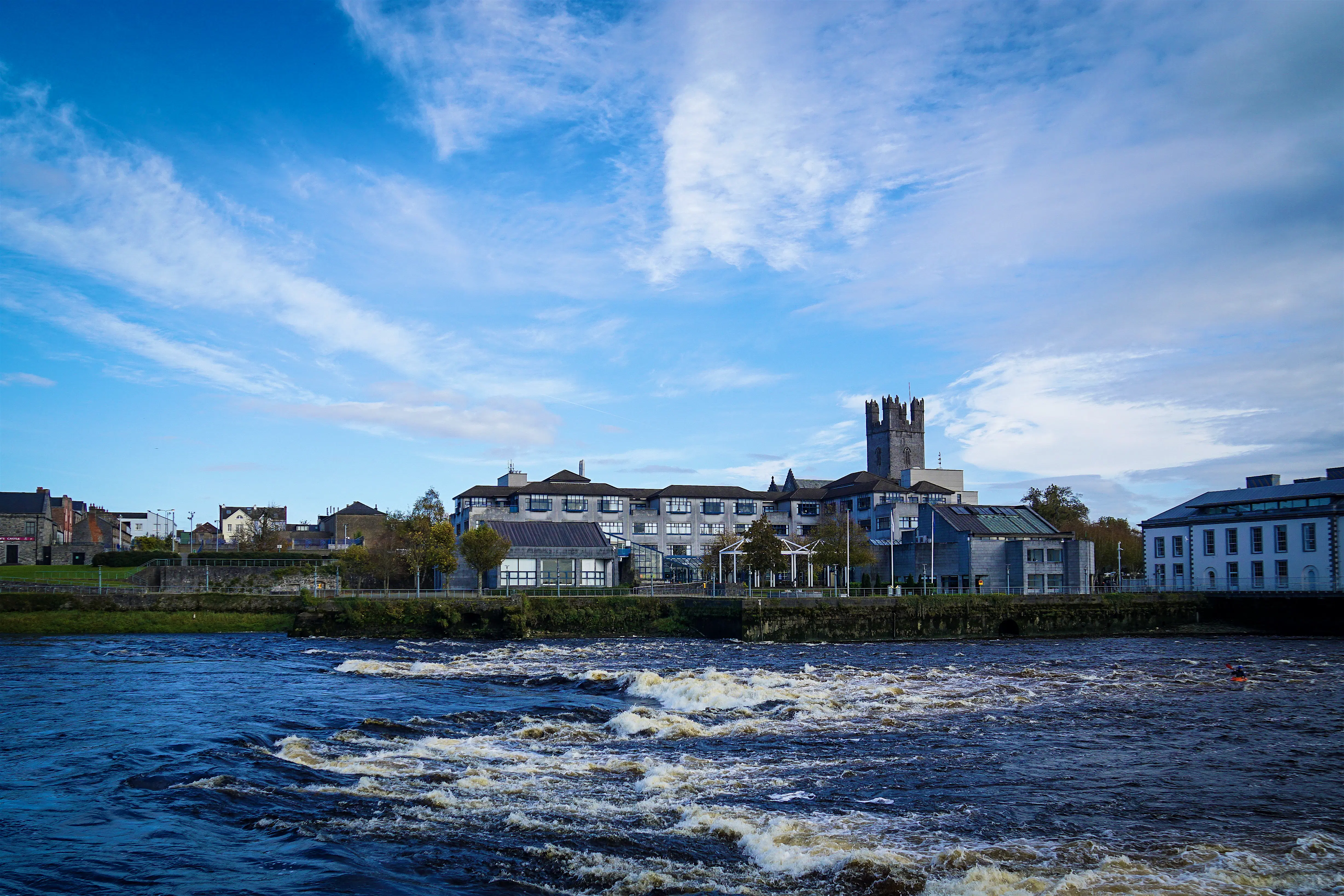 limerick-st-johns-castle-shannon.jpg The River Shannon is a deep blue and crested with low, white foamy waves as it laps against the shore where the city and King John's Castle sit