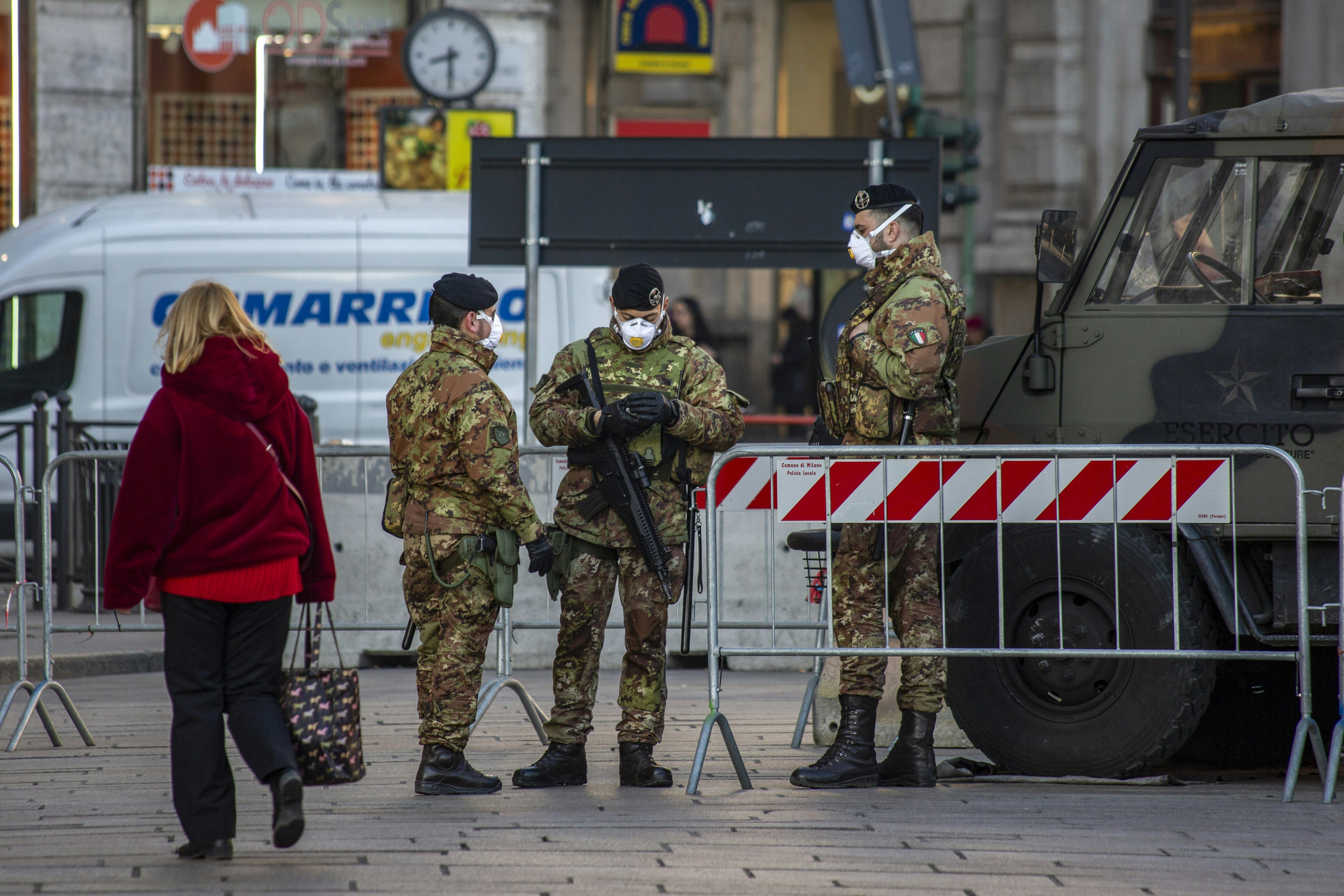Italian Army soldiers wear protective face masks as they stand on security near Duomo cathedral