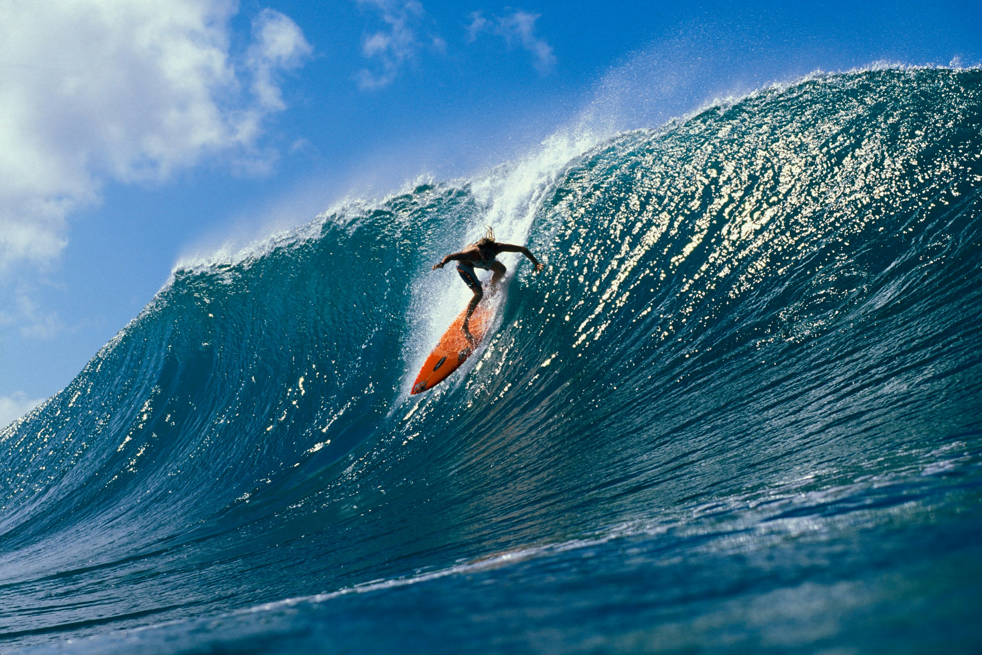 A surfer rides down a very large wave on the North Shore, one of O‘ahu’s highlights.