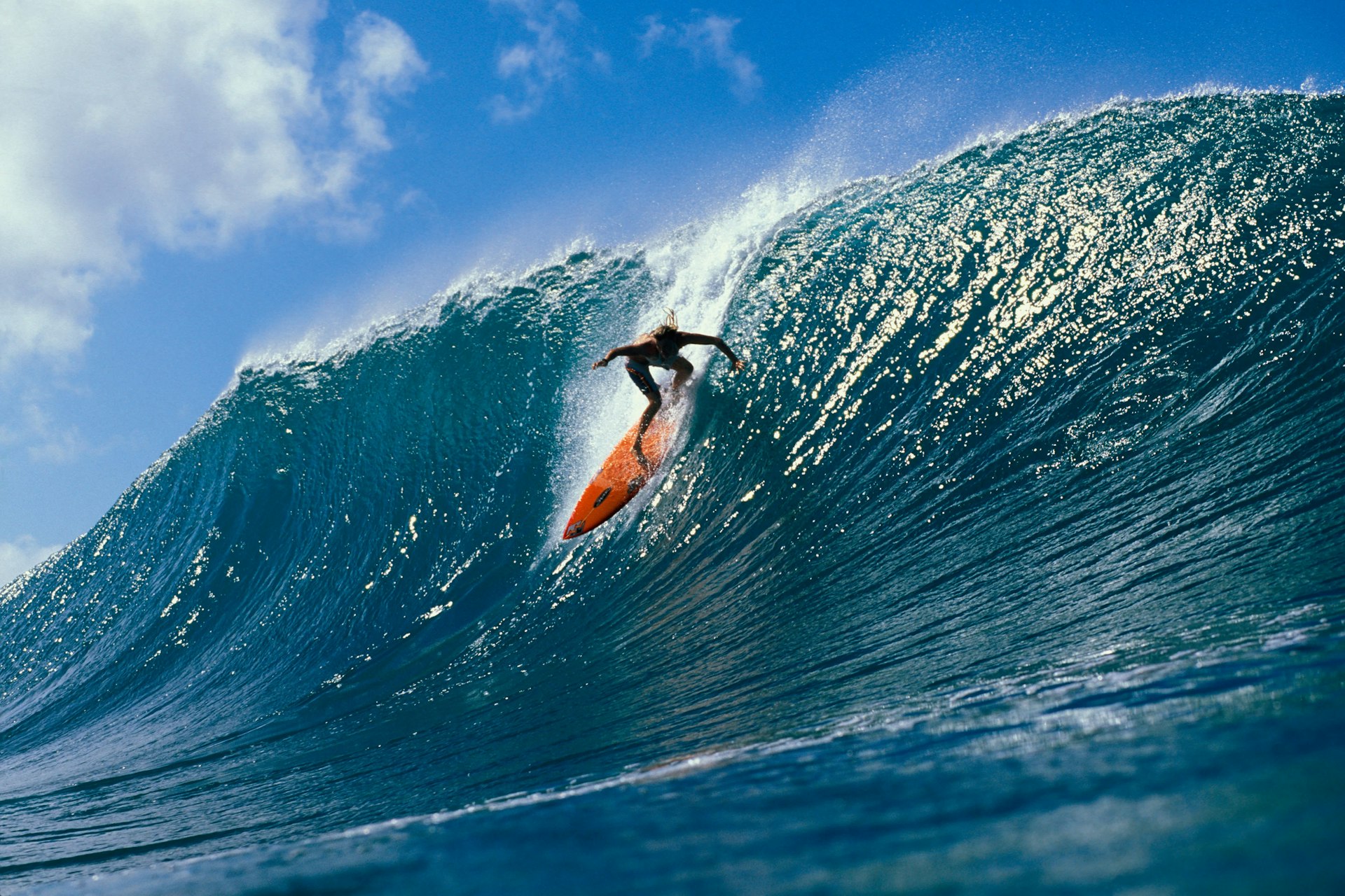 A surfer rides down a very large wave on the North Shore, one of O‘ahu’s highlights.