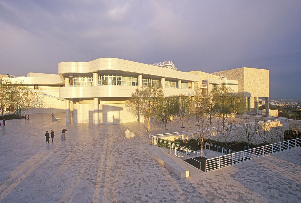 The white stone Getty Center arts complex is illuminated by a lilac sunset