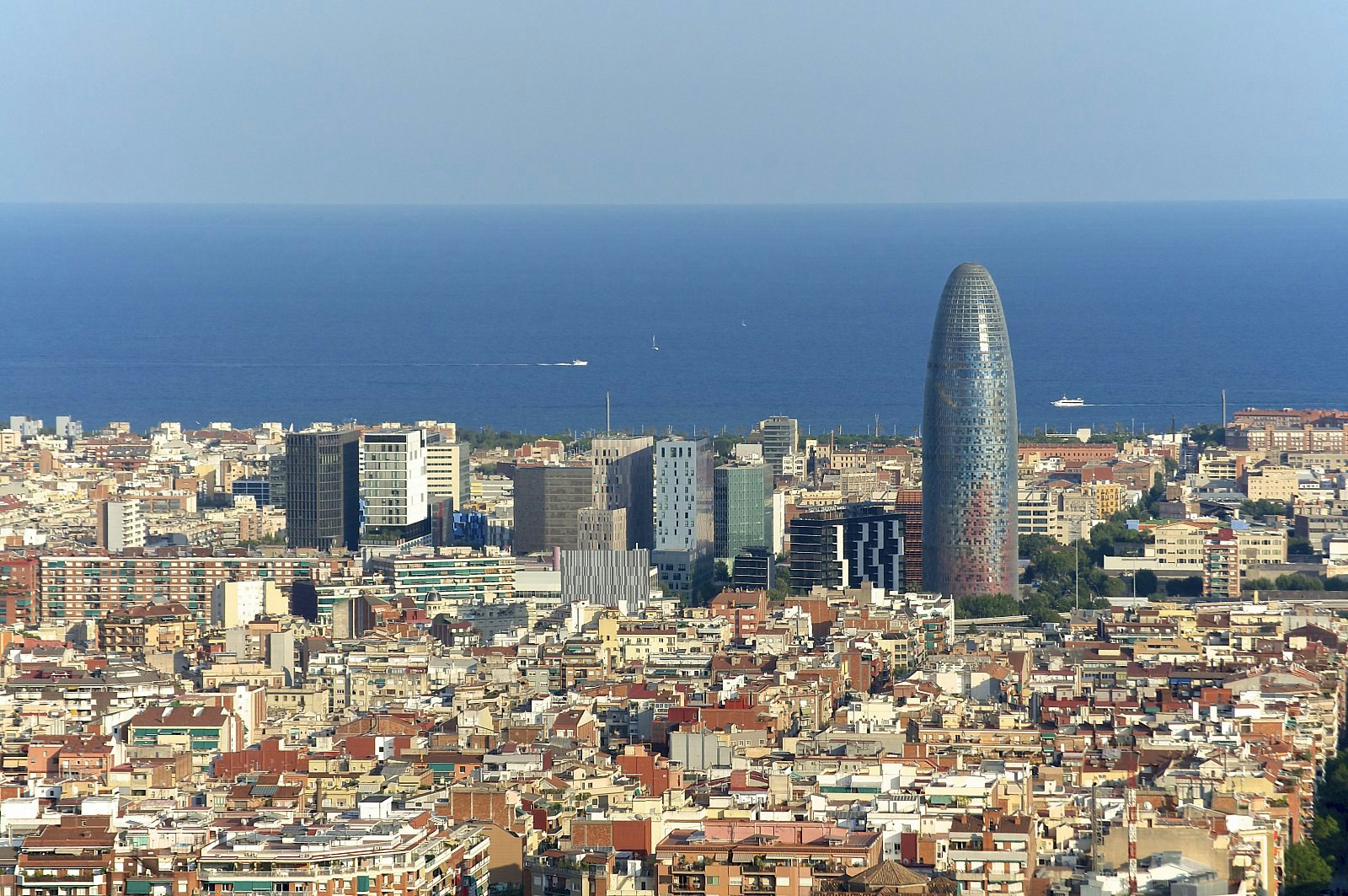 Looking over the skyline of Poblenou, with modern skyscrapers in the background and the blue Mediterranean beyond. 