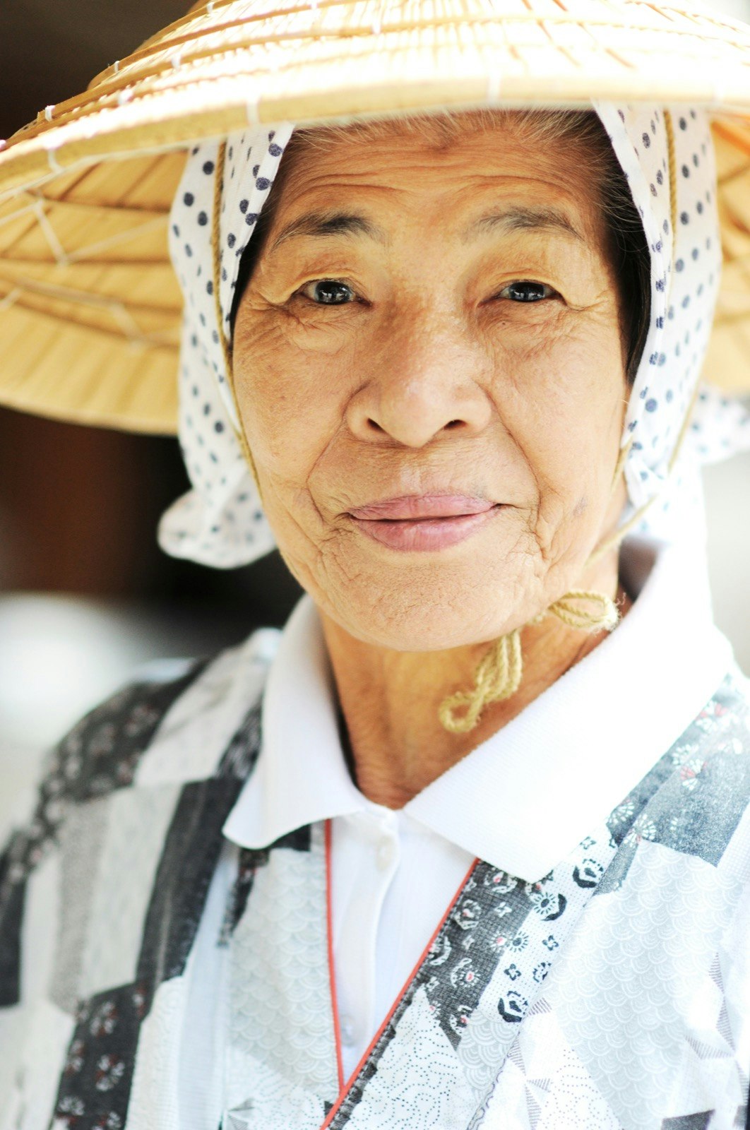 A close up of an older woman in a hatq