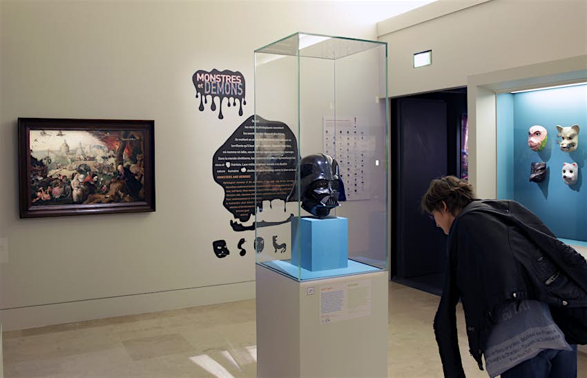 A black Darth Vader mask hangs in a display case in the Louvre's Petite Galerie