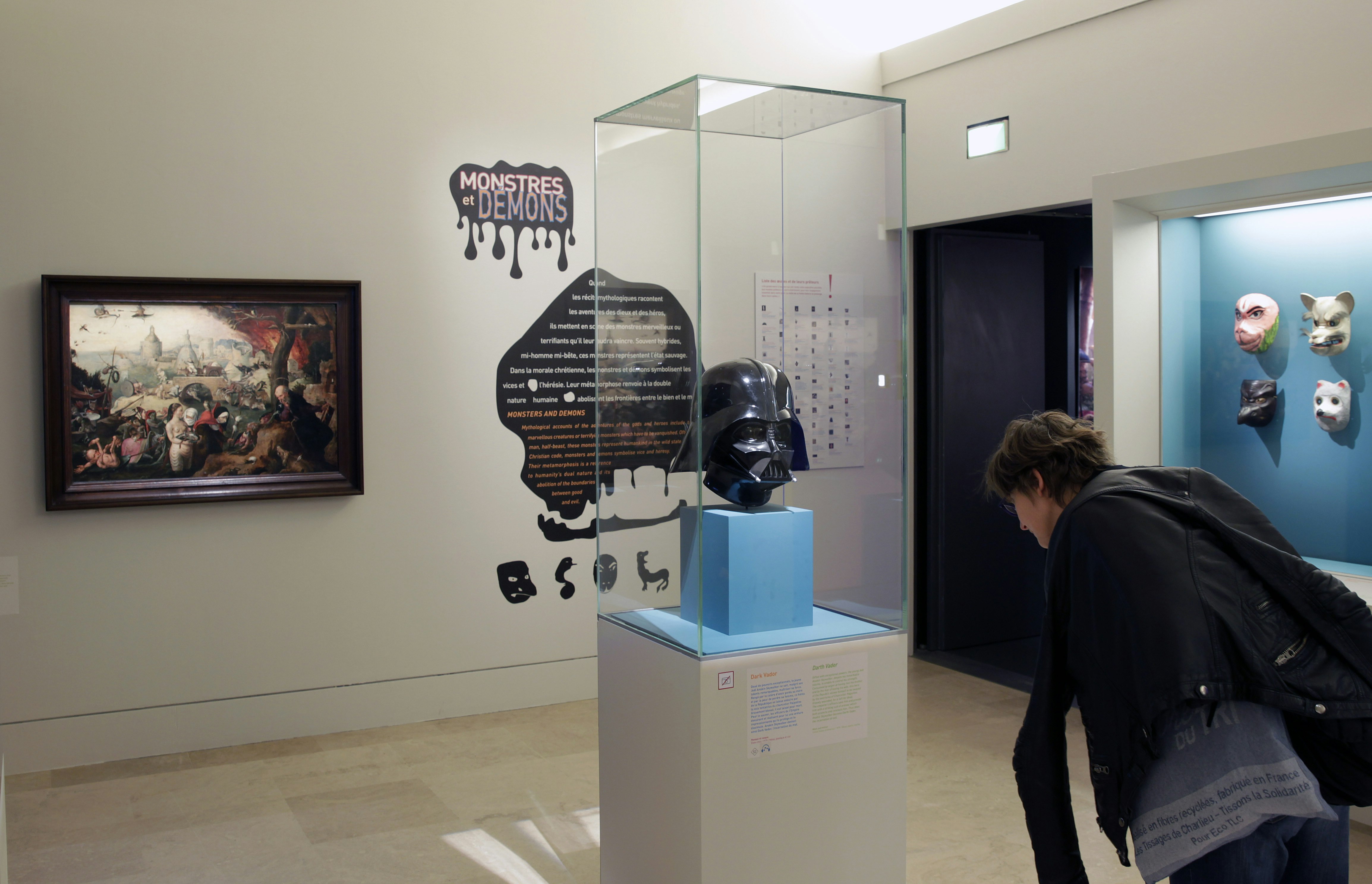 A black Darth Vader mask sits in a glass case in the Louvre's Petite Galerie