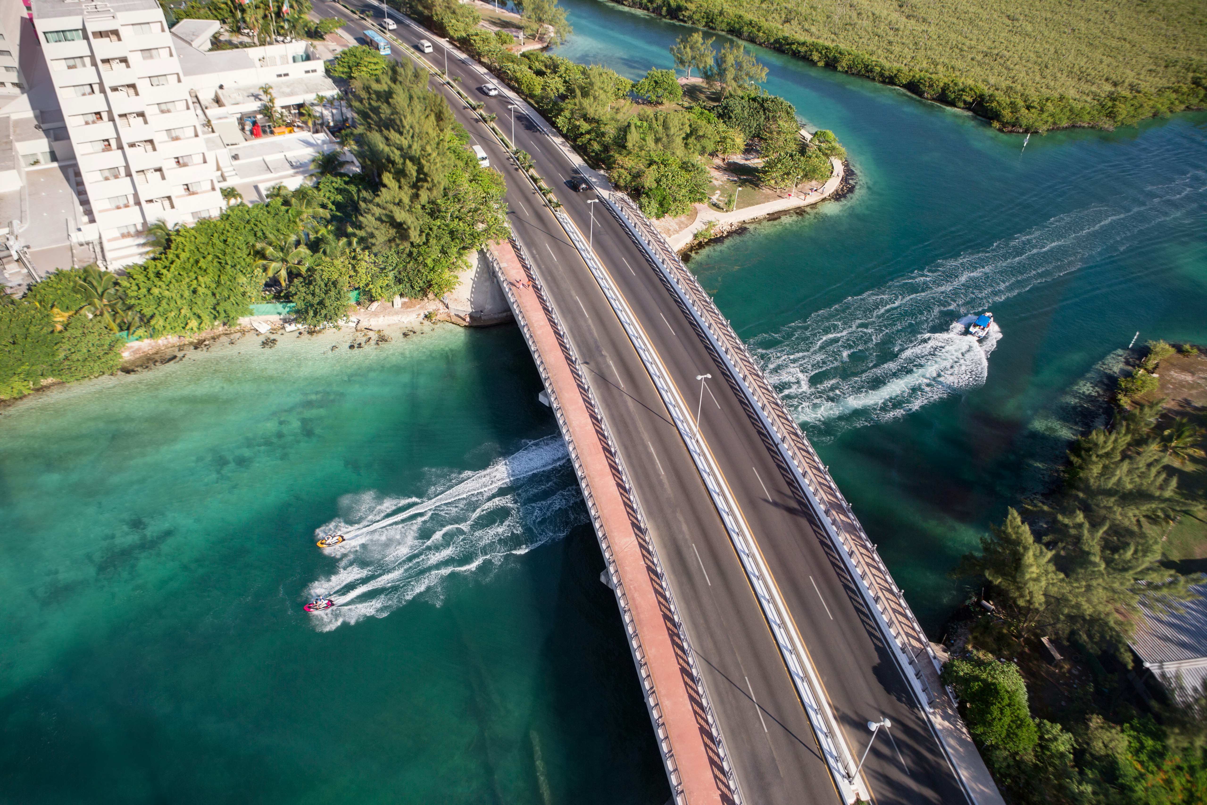 An aerial view of a highway over an bay with hotels on one side