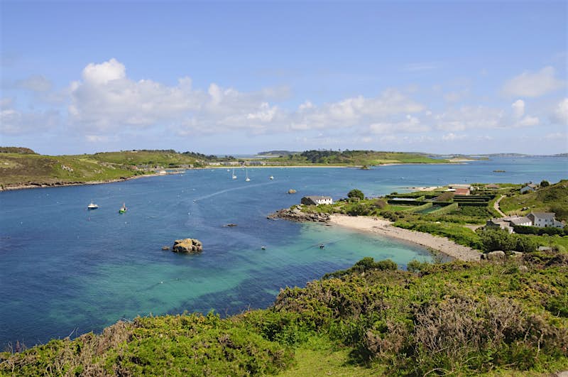 A view overlooking the shallow turquoise waters off the coast of Bryher, with neighbouring Tresco island in the background.