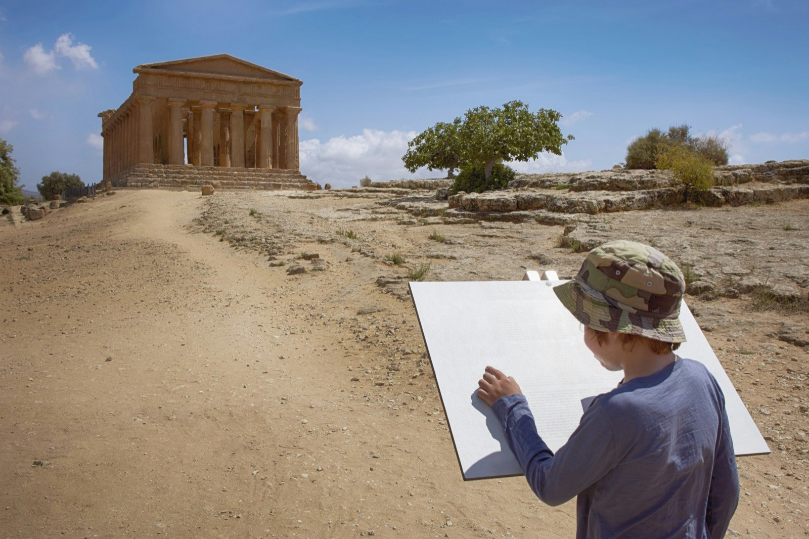 a boy sketches before an Italian ruin