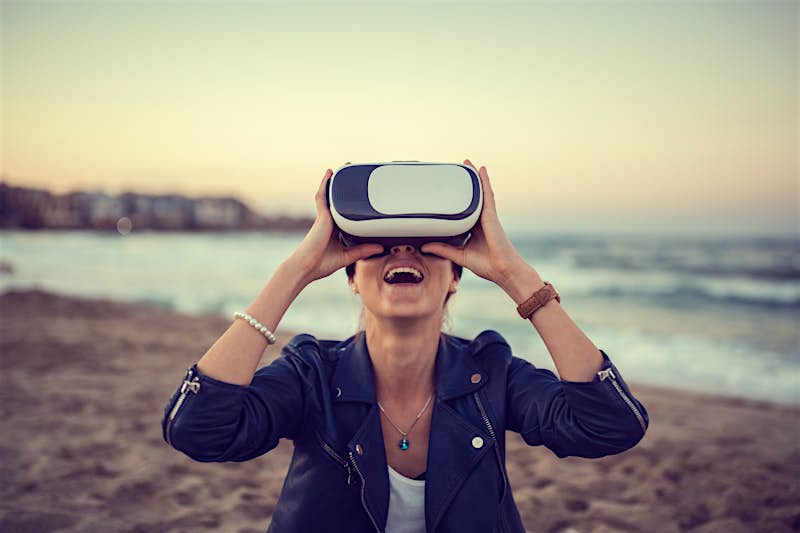 Woman enjoying a VR simulator at the beach