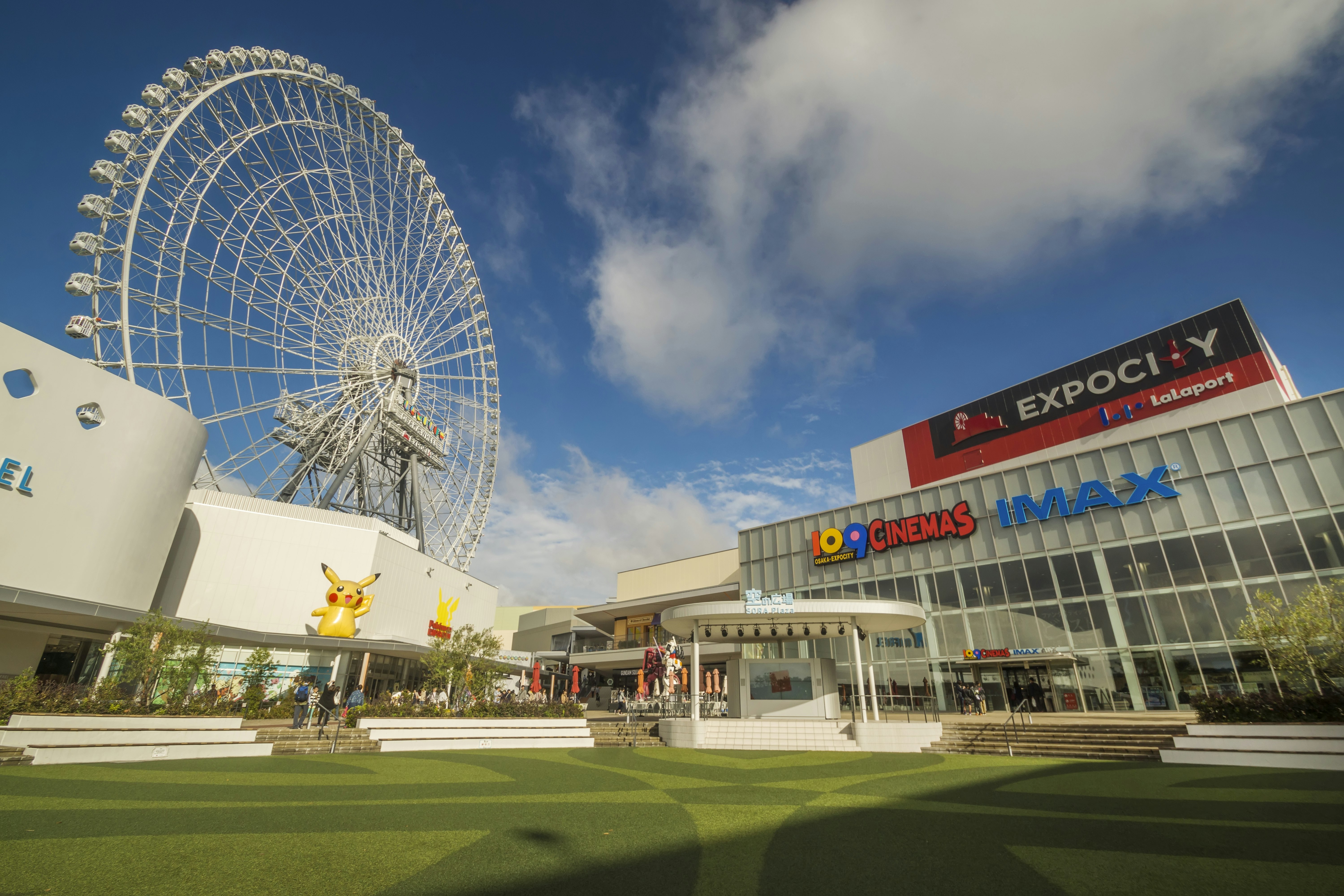 A large entertainment and shopping complex with a Ferris wheel in the background