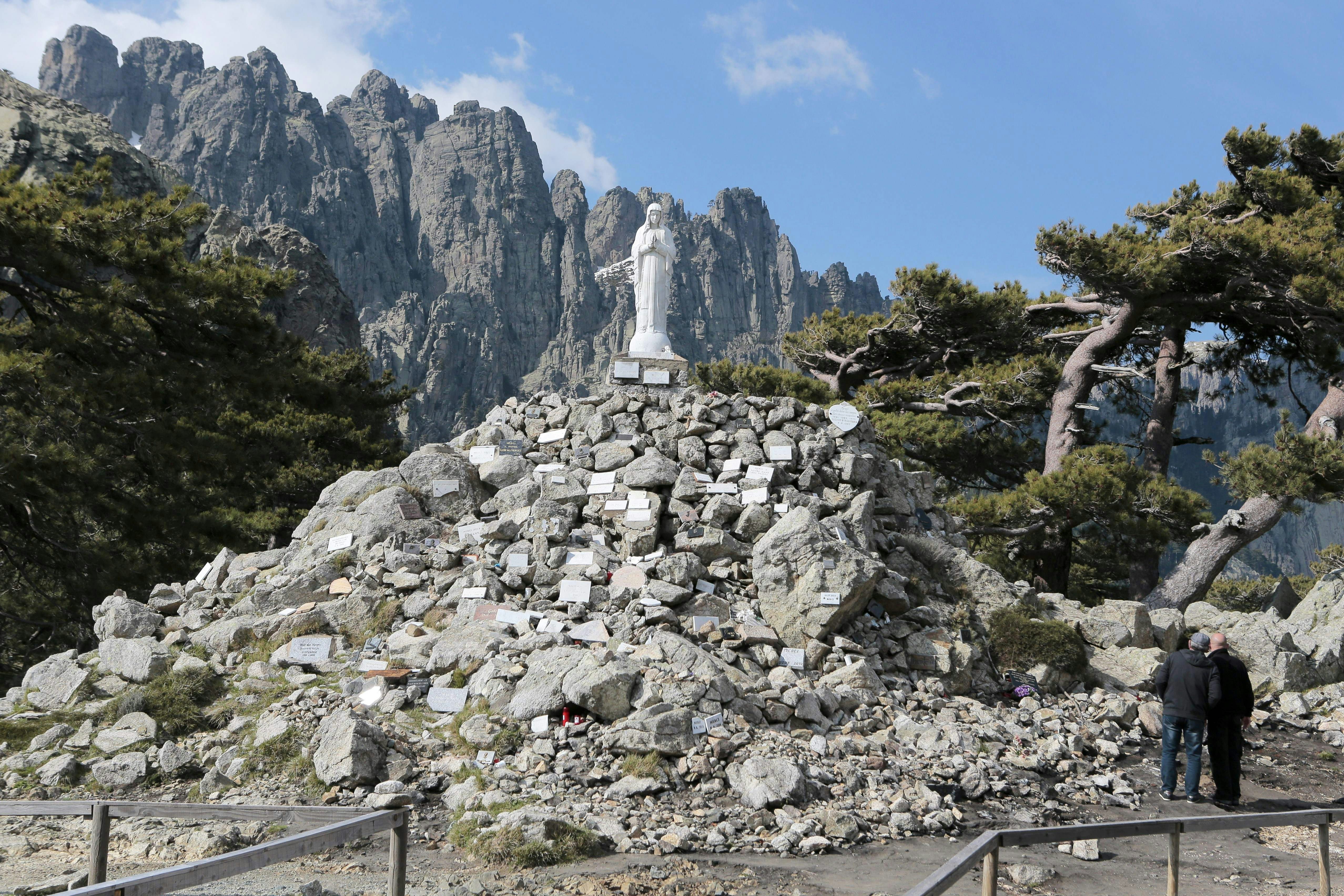 The Notre-Dame des Neiges (our lady of the snows) statue stands on the G20's Bavella pass. It's a solid grey statue of the Virgin Mary with her hands clasped in brayer standing atop a cairn of stones. 
