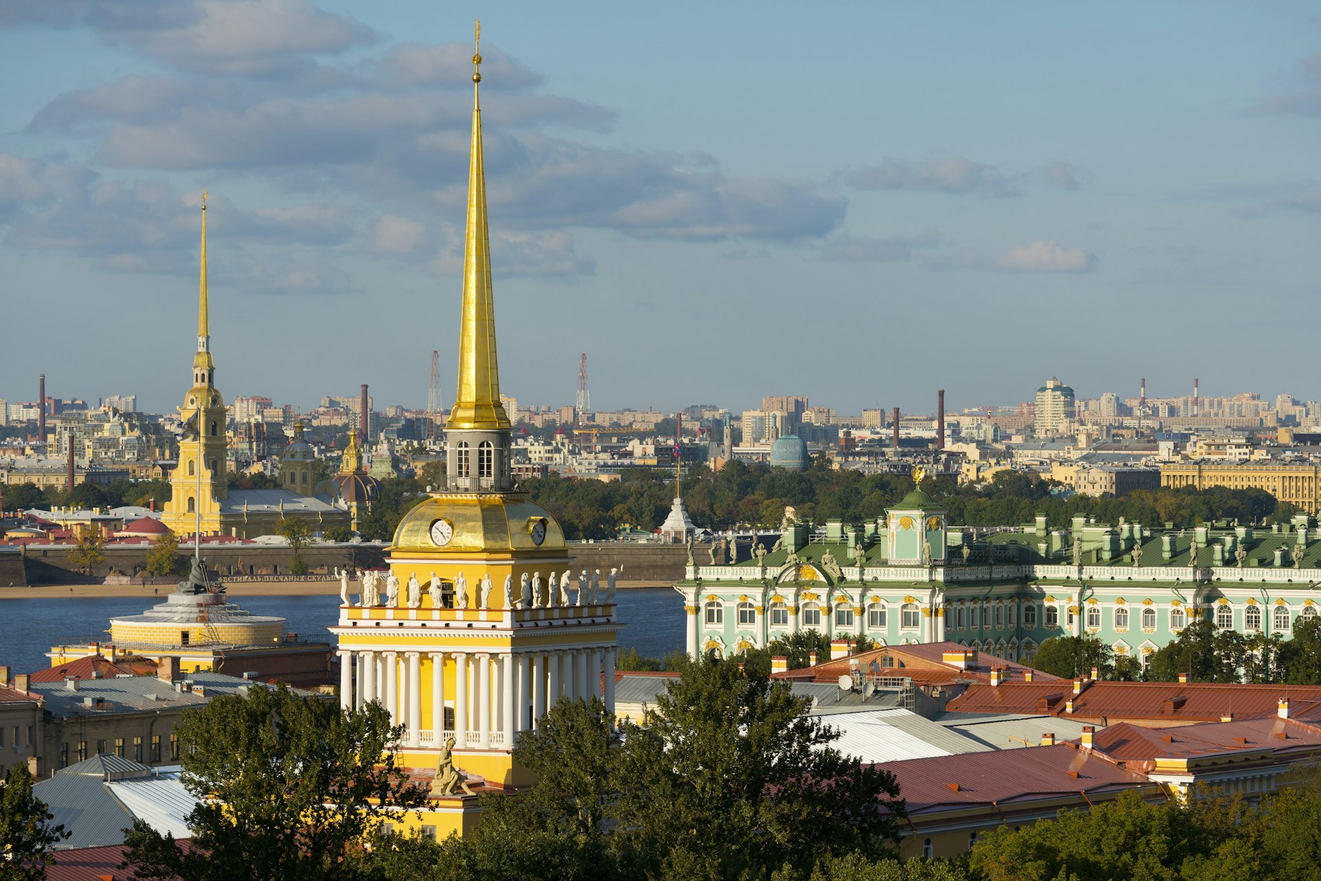 An aerial view of St Petersburg's landmark architecture, with golden spires and ornate facades visible beneath a blue sky