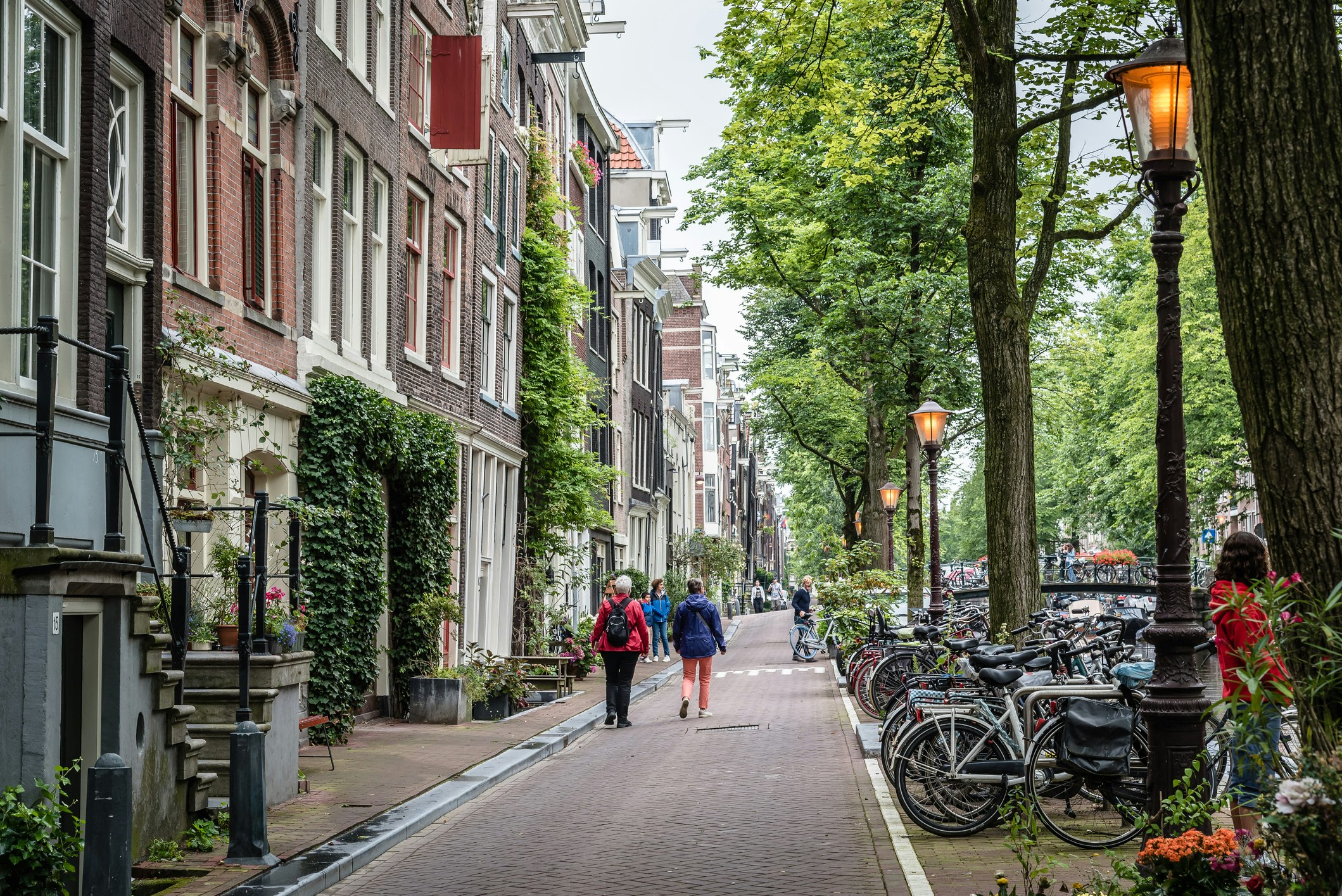 Rear View Of People Walking On Footpath By Typical Dutch Buildings