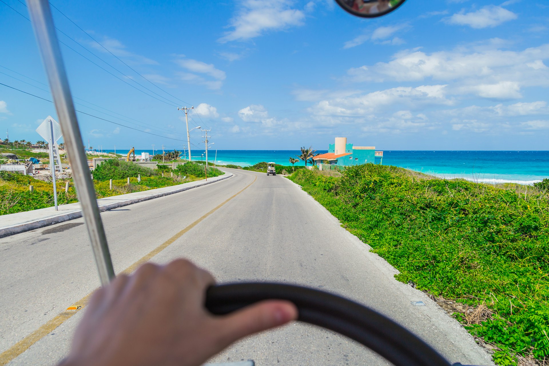 A man steering a wheel with the beach in the distance