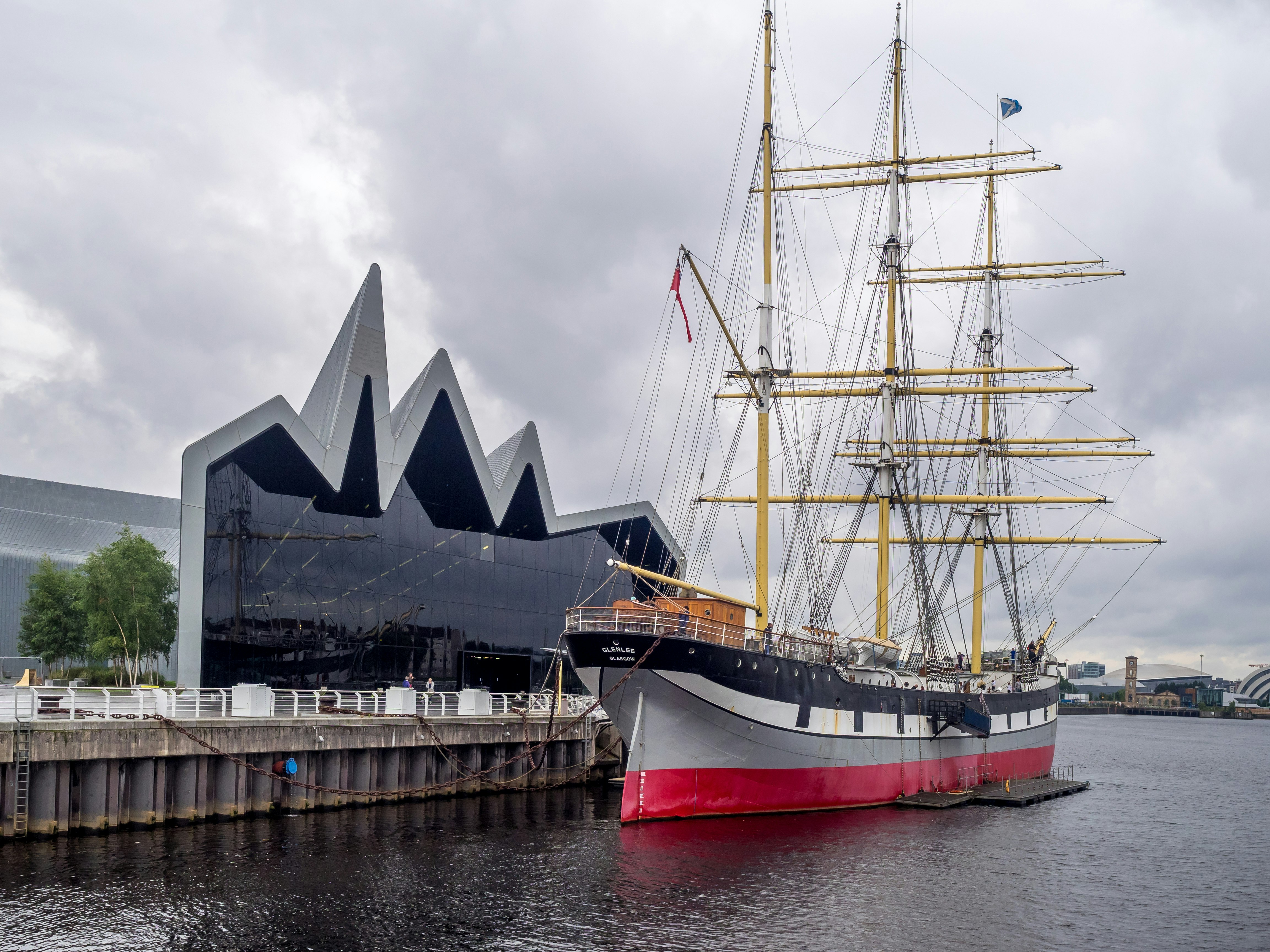 Glasgow's striking modern Riverside Museum building with its jagged glass facade, and the three-masted Tall Ship in front.