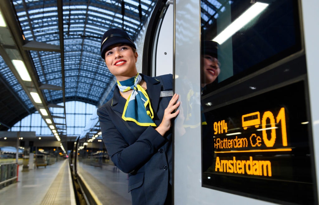 Eurostar female staff member in uniform peeks out of passenger door on train