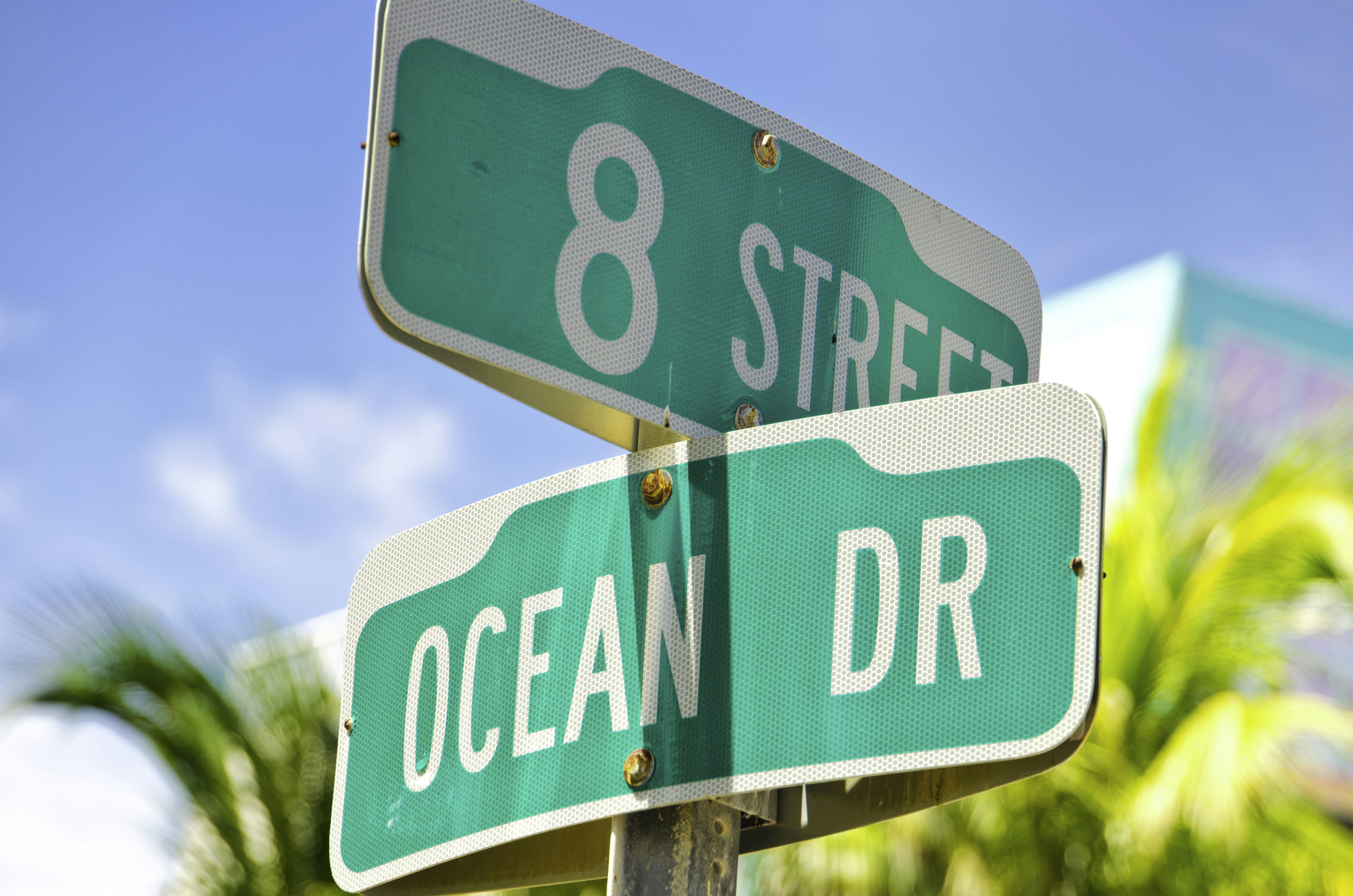 Close up of a green street sign in Miami. The streets on the sign are 8th Street and Ocean Drive.