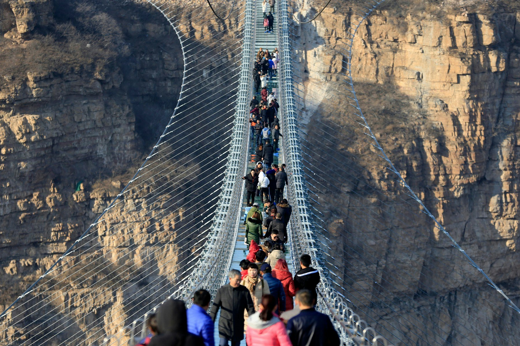 People crosssing a glass bridge in China