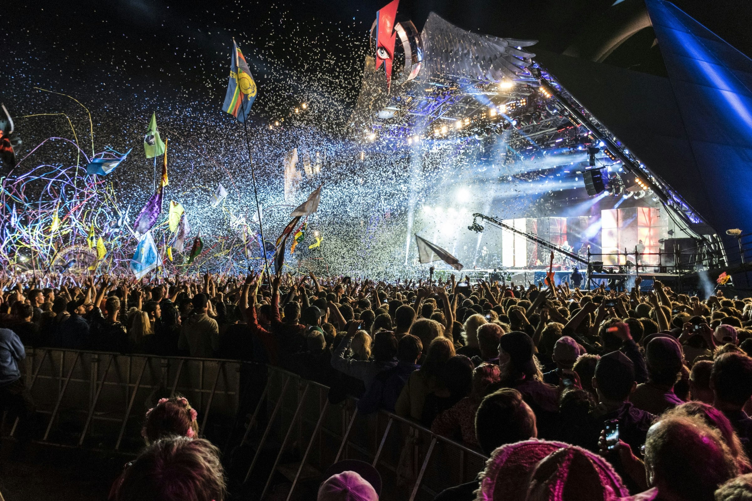 An explosion of confetti, tape and light from a pyramid shaped stage at Glastonbury Festival.