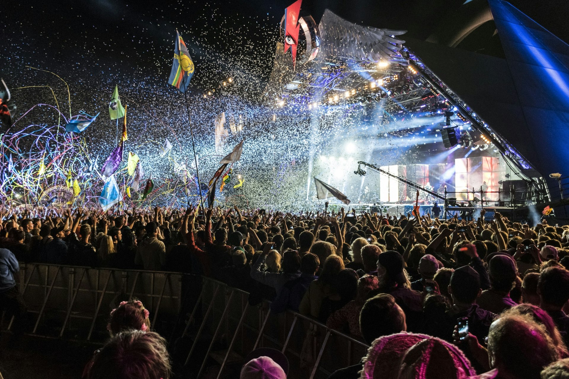 An explosion of confetti, tape and light from a pyramid shaped stage at Glastonbury Festival.