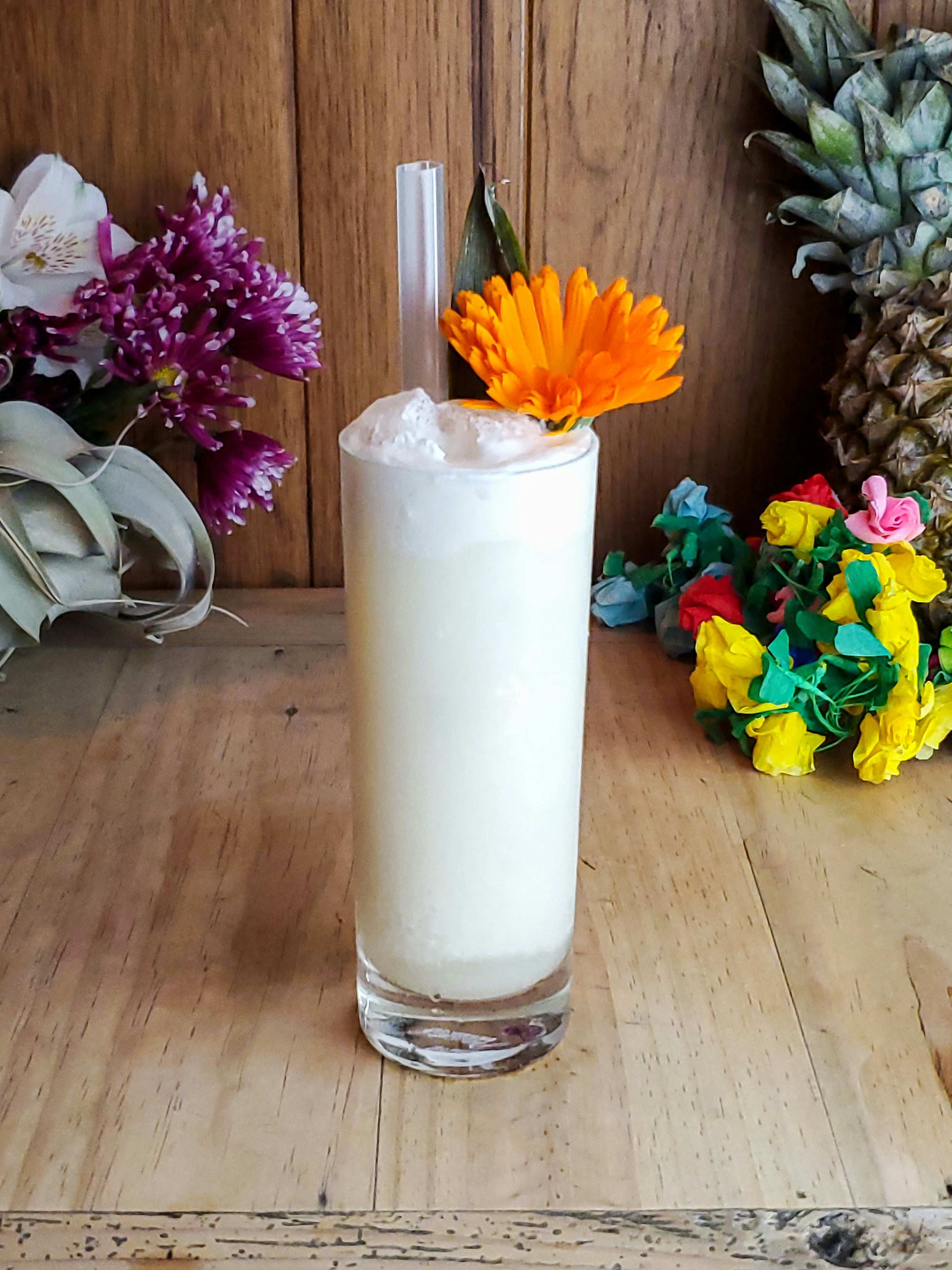 A large creamy drink is garnished with an orange flower and large straw; LA vegan resturants