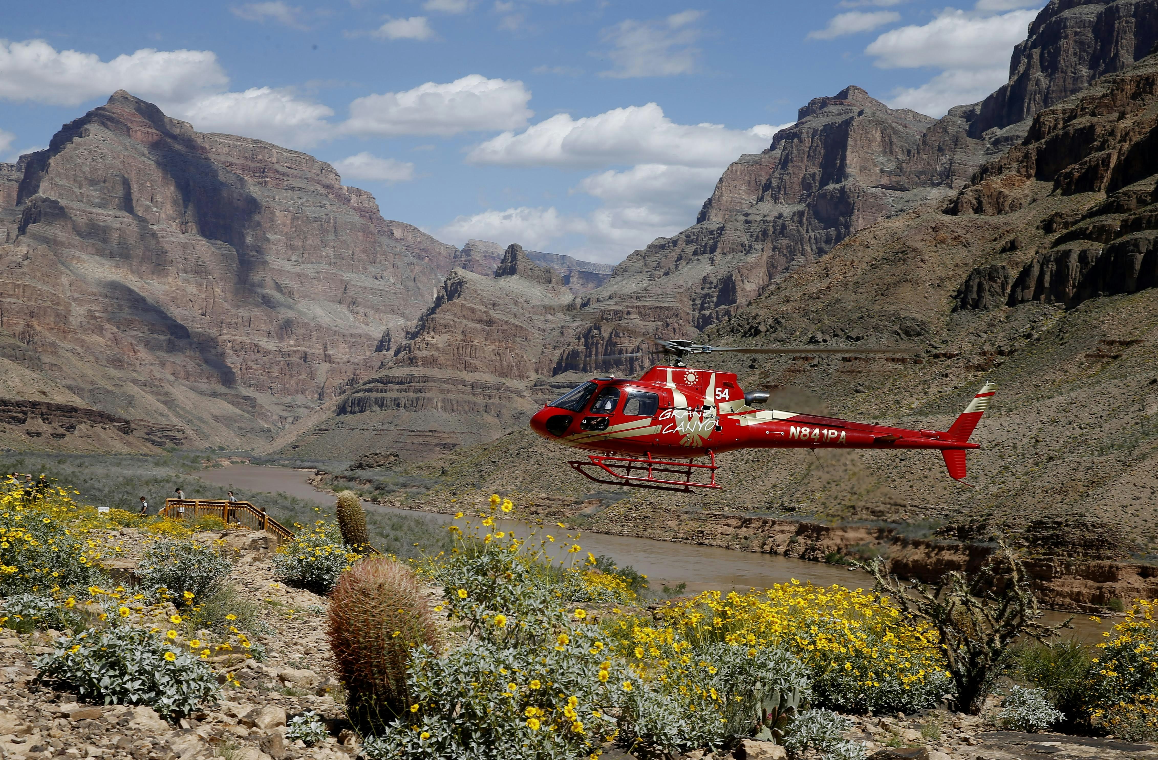 A helicopter takes off from the rim of the Grand Canyon