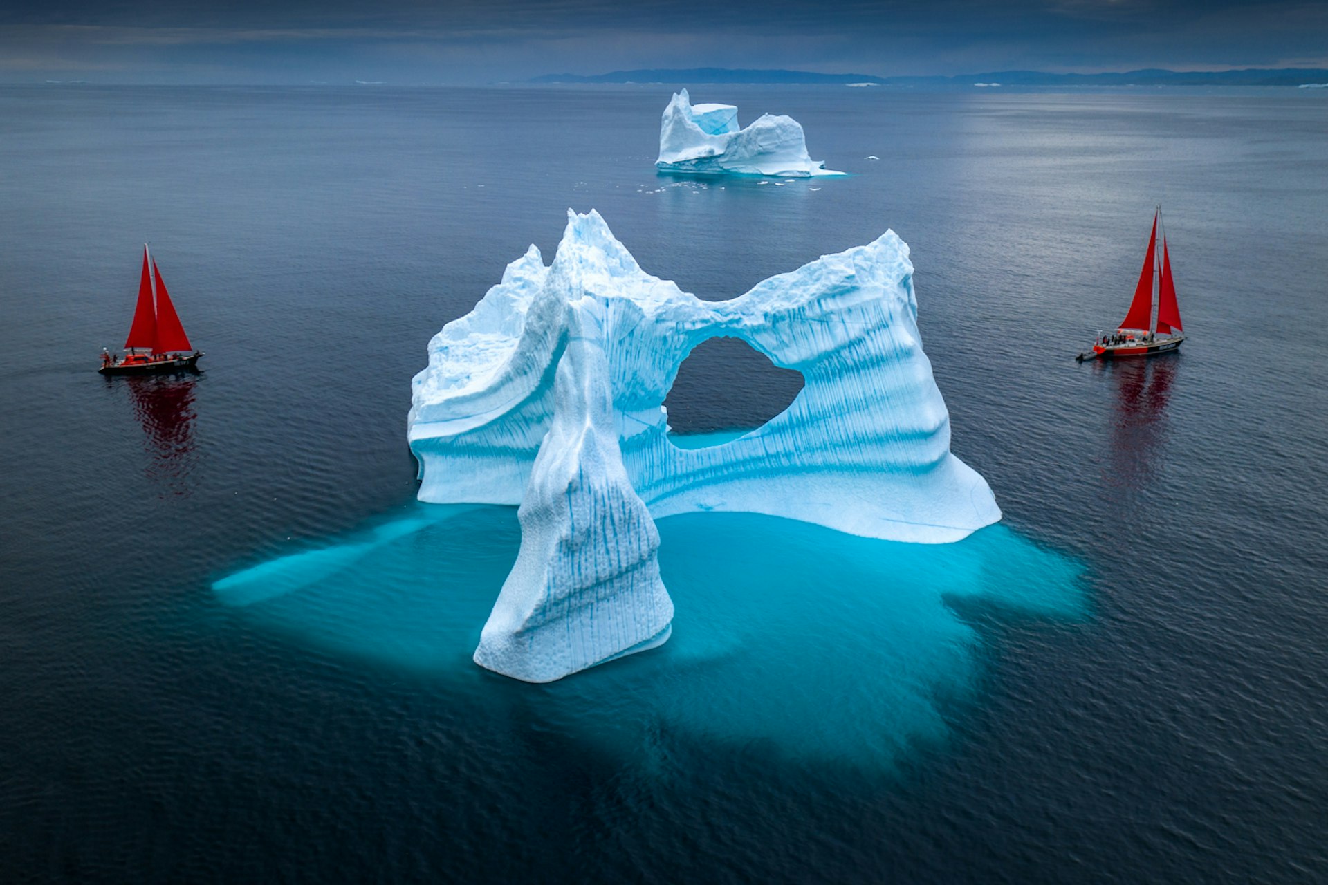two sail boats around a stunning glacier in Greenland