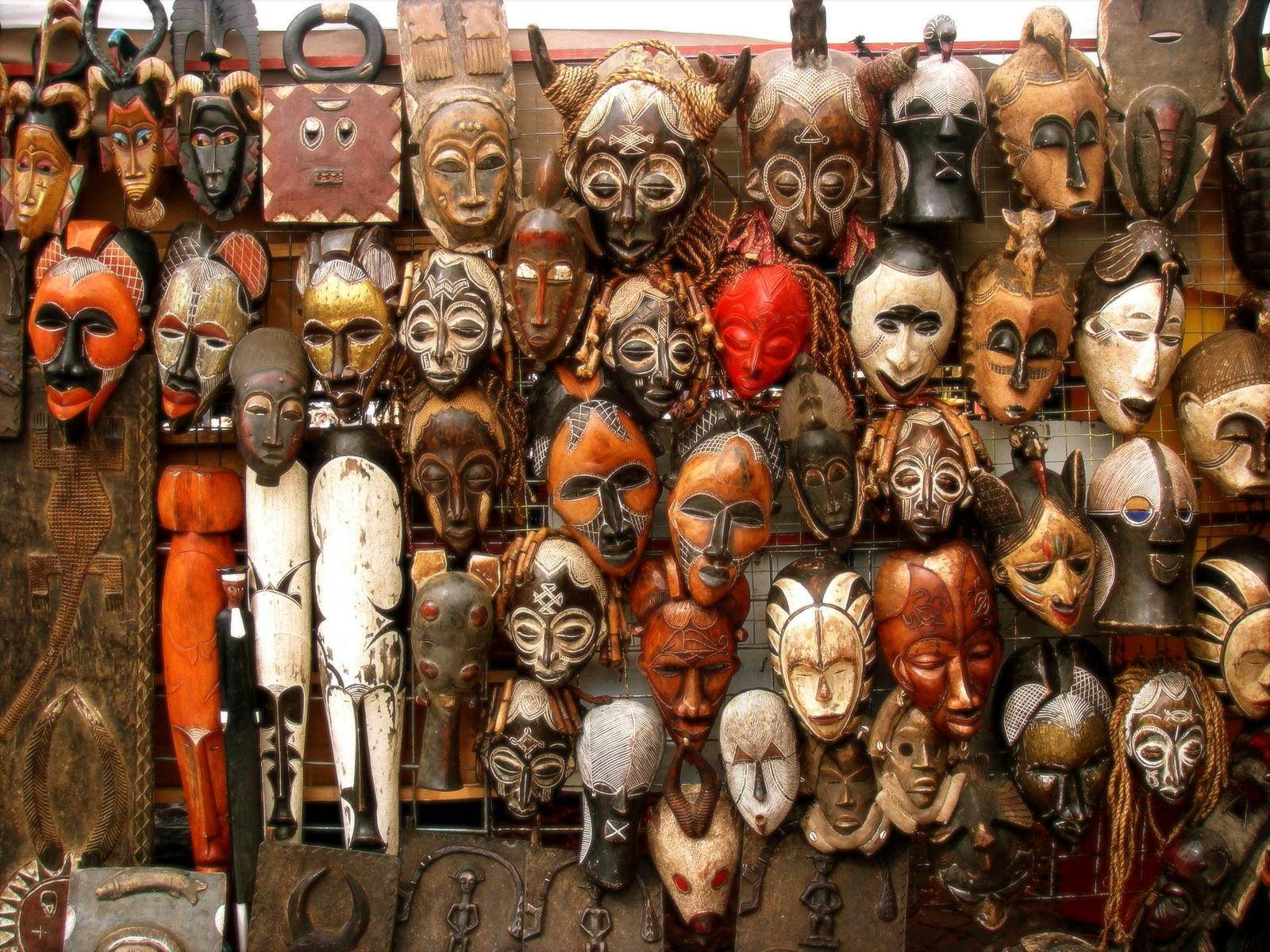 A wall is covered in traditional carved wooden masks from across Africa.