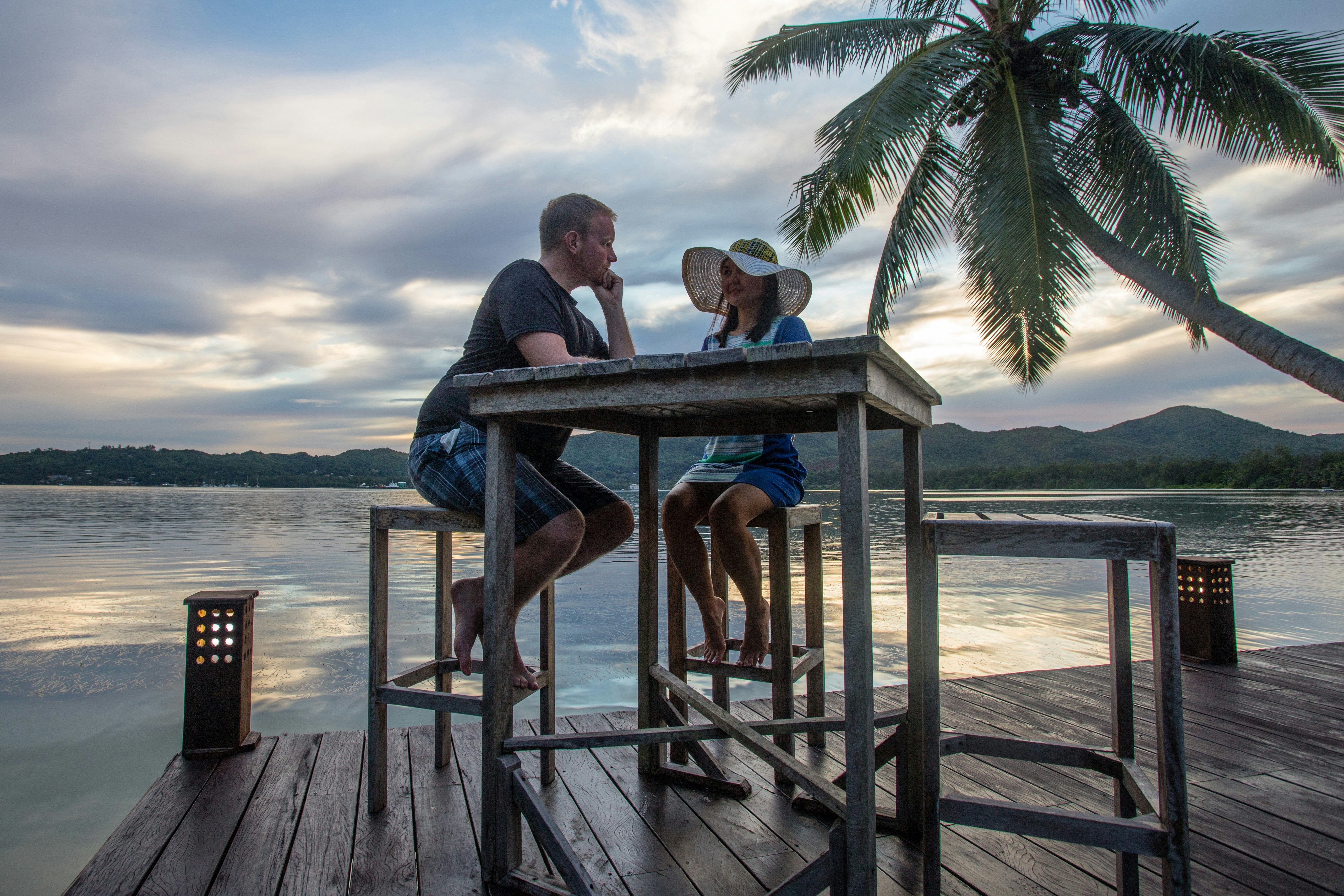 A honeymoon couple look loving at one at sunset at Anse Madge on Praslin Island in the Seychelles